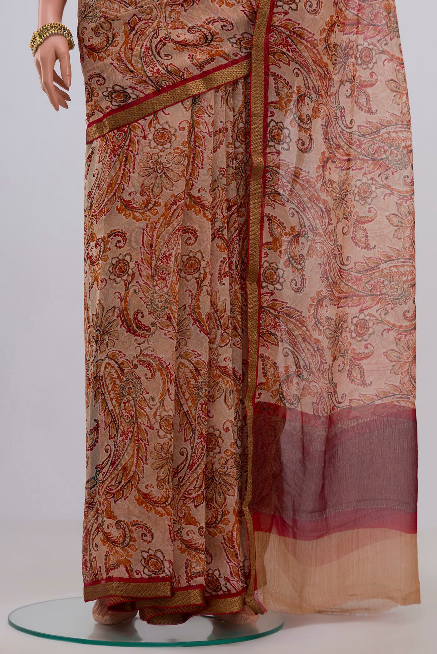 Pleats and pallu of Cream Chiffon Saree with Printed design on the body and Zari Border. 