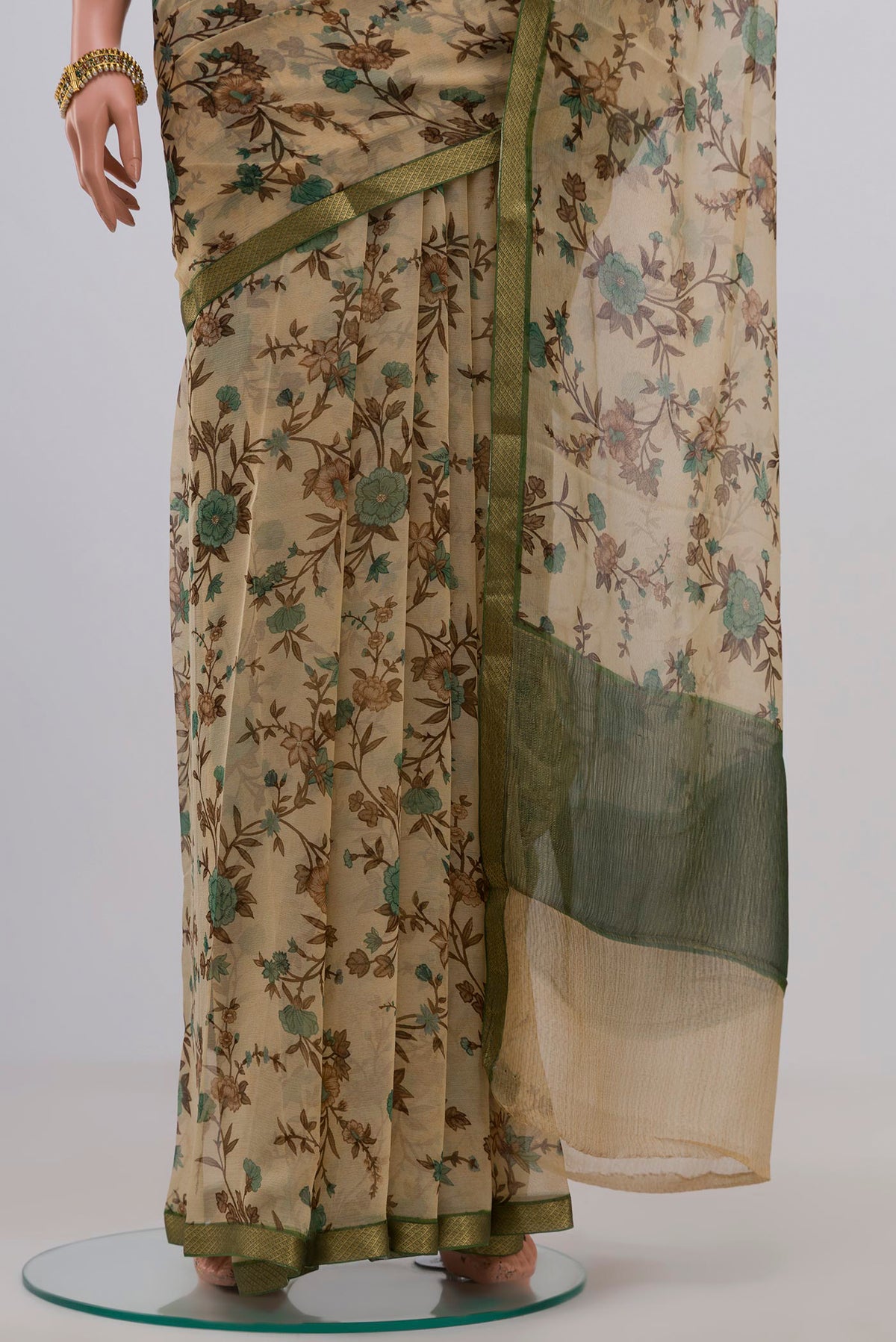 Pleats and pallu of Cream Chiffon Saree with Printed design on the body and Zari Border. 