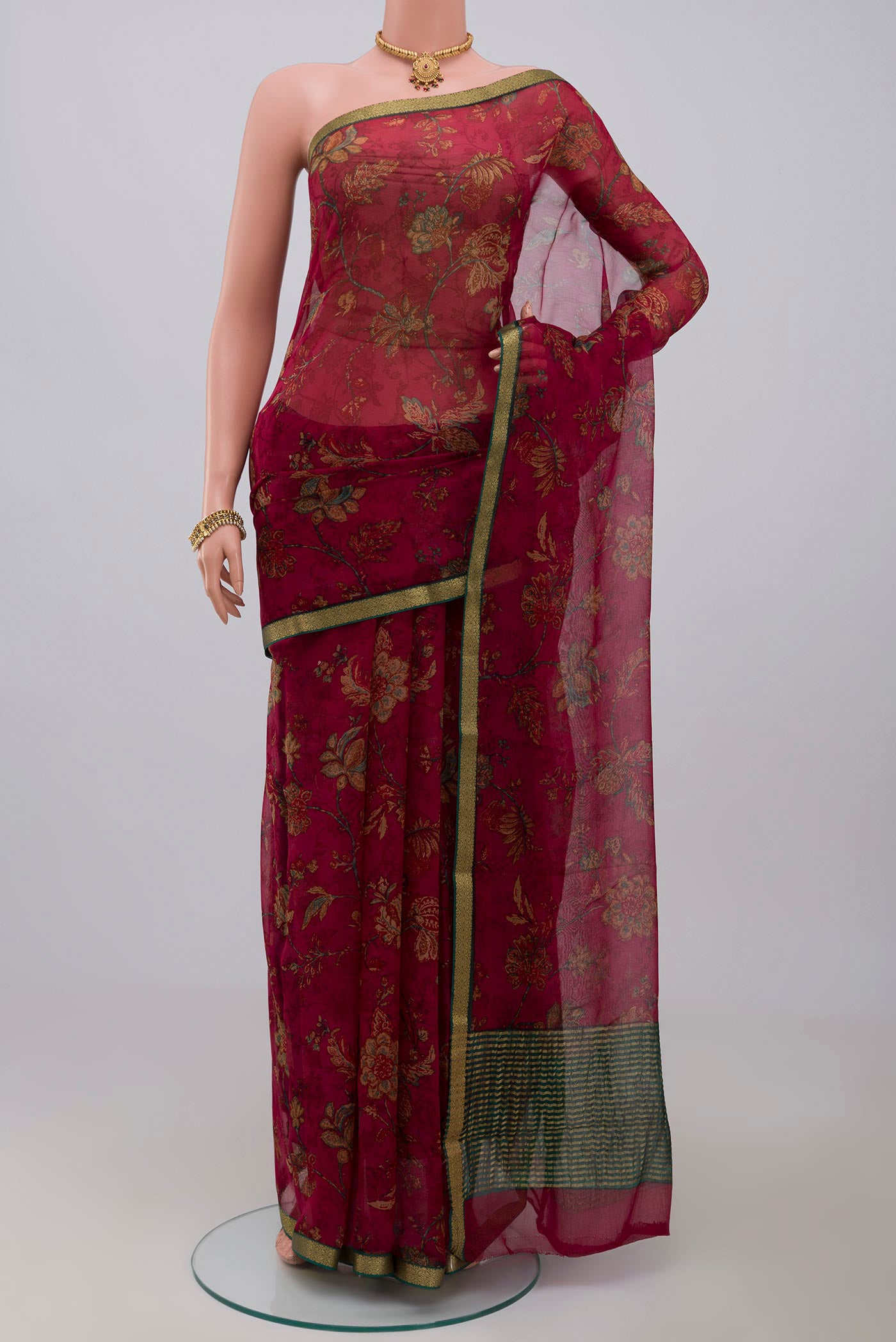 Maroon Chiffon Saree with Printed design on the body and Thin Zari Line.  displayed on a mannequin
