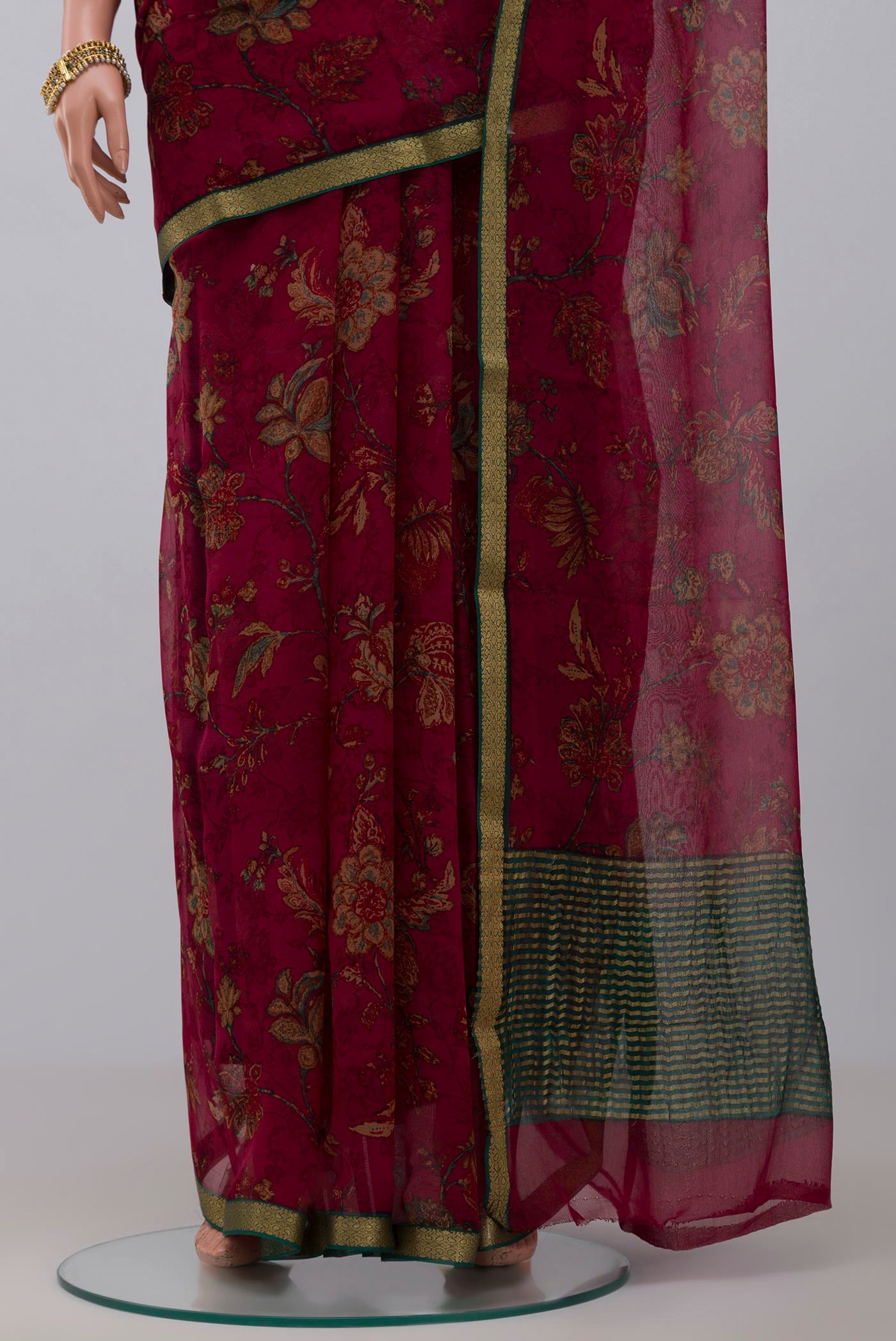 Pleats and pallu of Maroon Chiffon Saree with Printed design on the body and Thin Zari Line. 