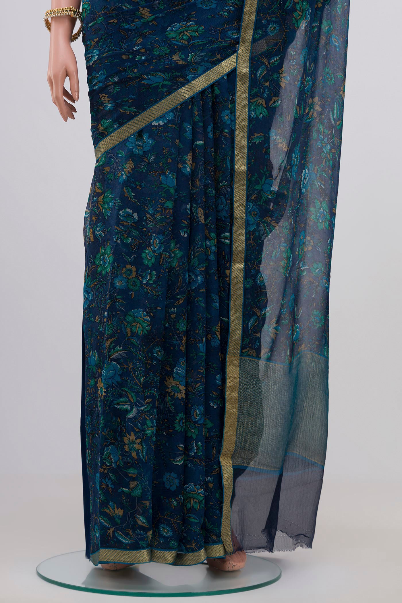 Pleats and pallu of Blue Chiffon Saree with Printed design on the body and Zari Border. 