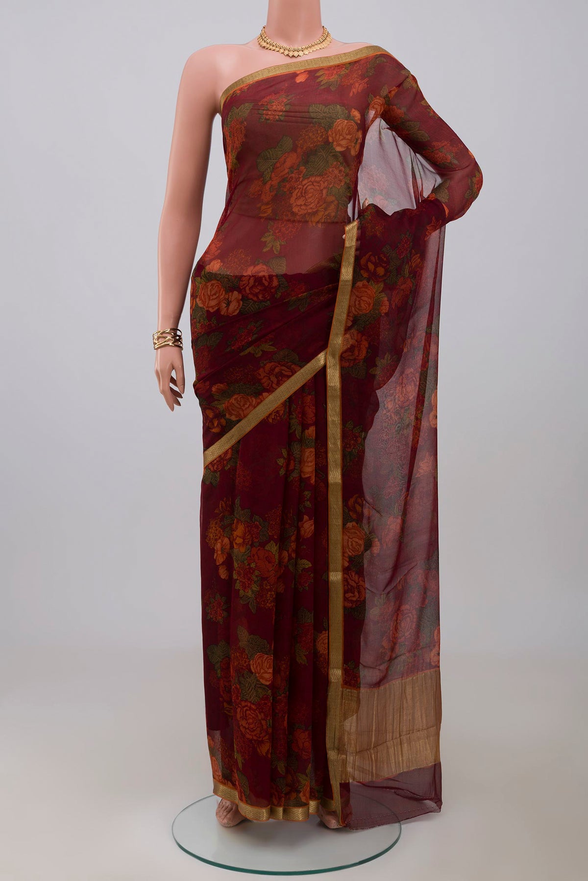 Maroon Chiffon Saree with Printed design on the body and Zari Border.  displayed on a mannequin