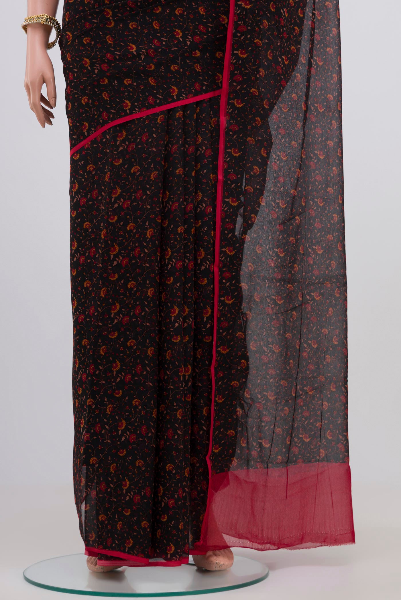 Pleats and pallu of Black Chiffon Saree with Printed design on the body and Plain Border. 
