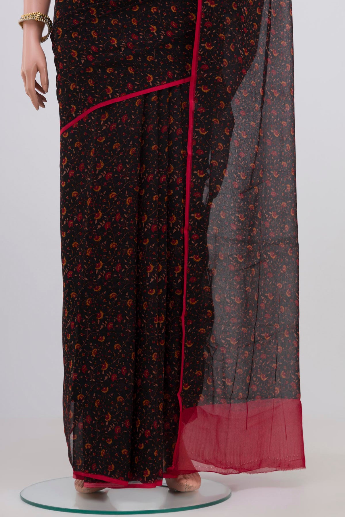 Pleats and pallu of Black Chiffon Saree with Printed design on the body and Plain Border. 