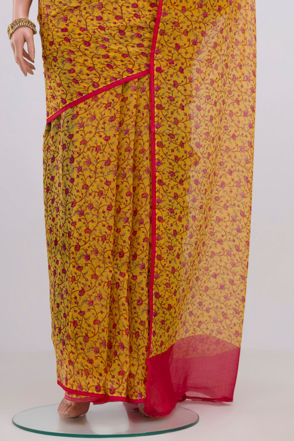 Pleats and pallu of Yellow Chiffon Saree with Printed design on the body and Without Border. 