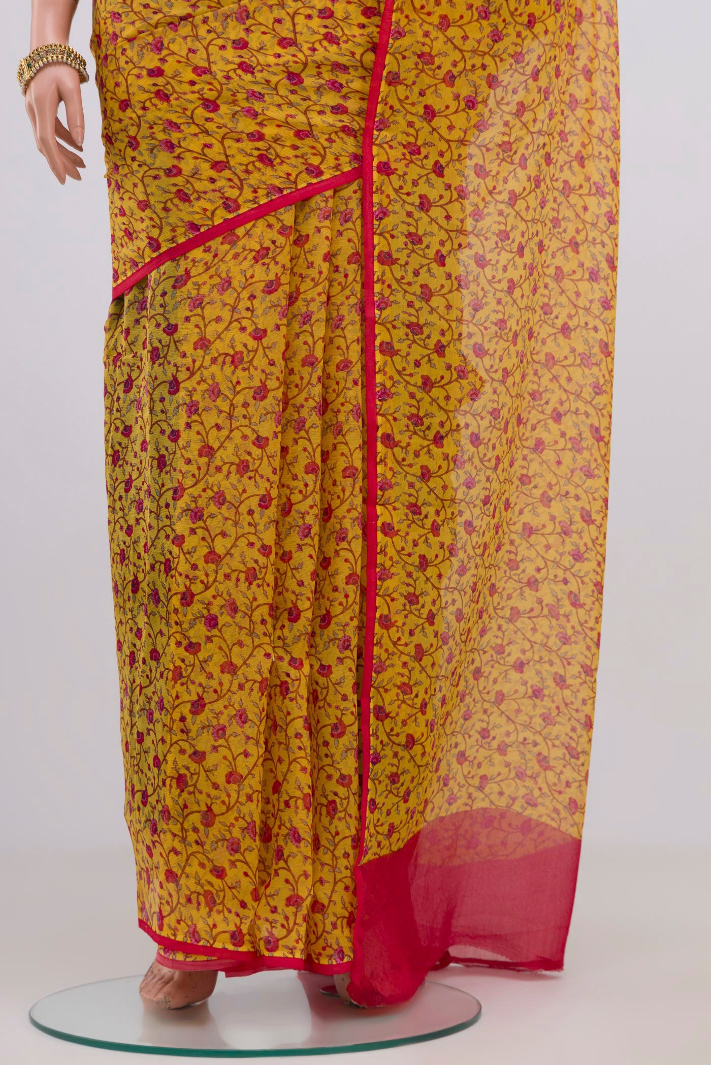 Pleats and pallu of Yellow Chiffon Saree with Printed design on the body and Without Border. 