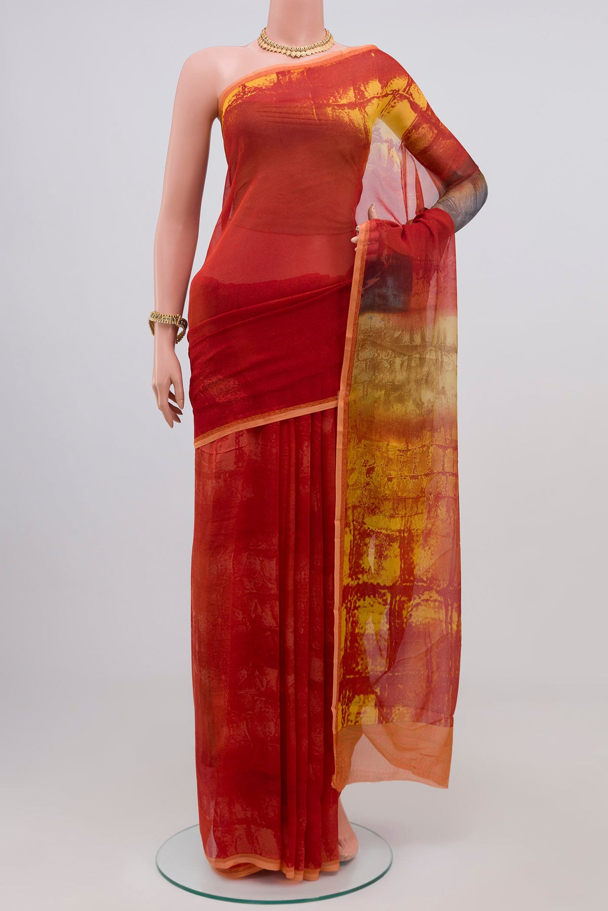 Orange Chiffon Saree with Printed design on the body and Plain Border.  displayed on a mannequin
