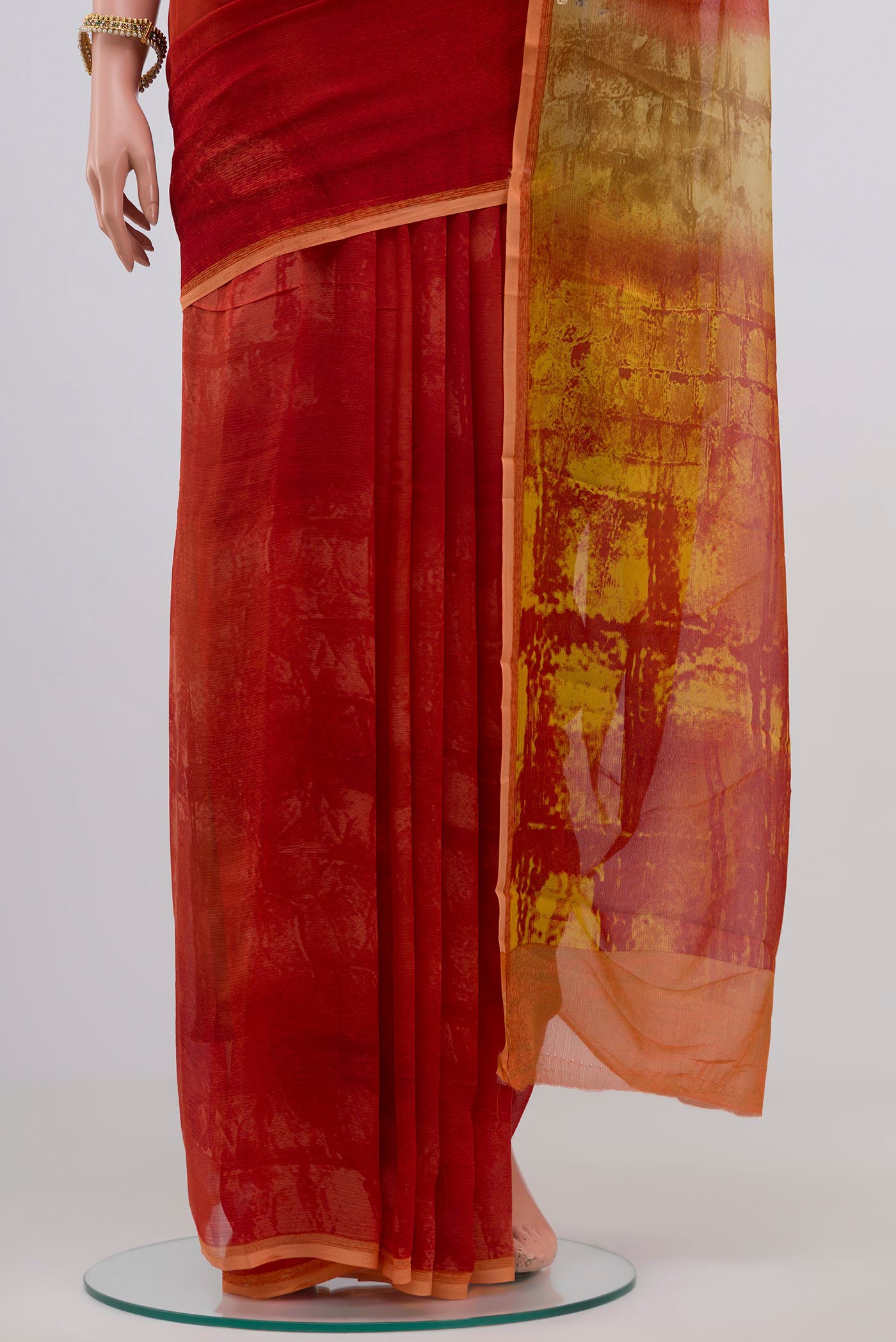 Pleats and pallu of Orange Chiffon Saree with Printed design on the body and Plain Border. 