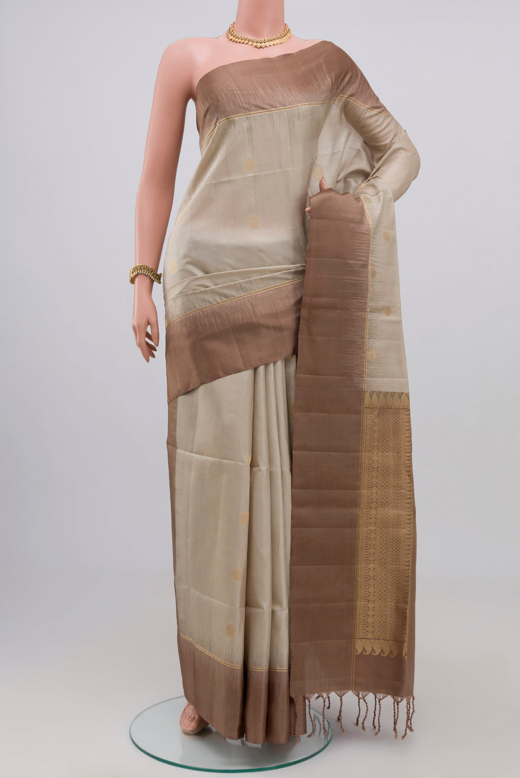 Beige Soft Silk Saree with Zari Butta on the body and Plain Border.  displayed on a mannequin