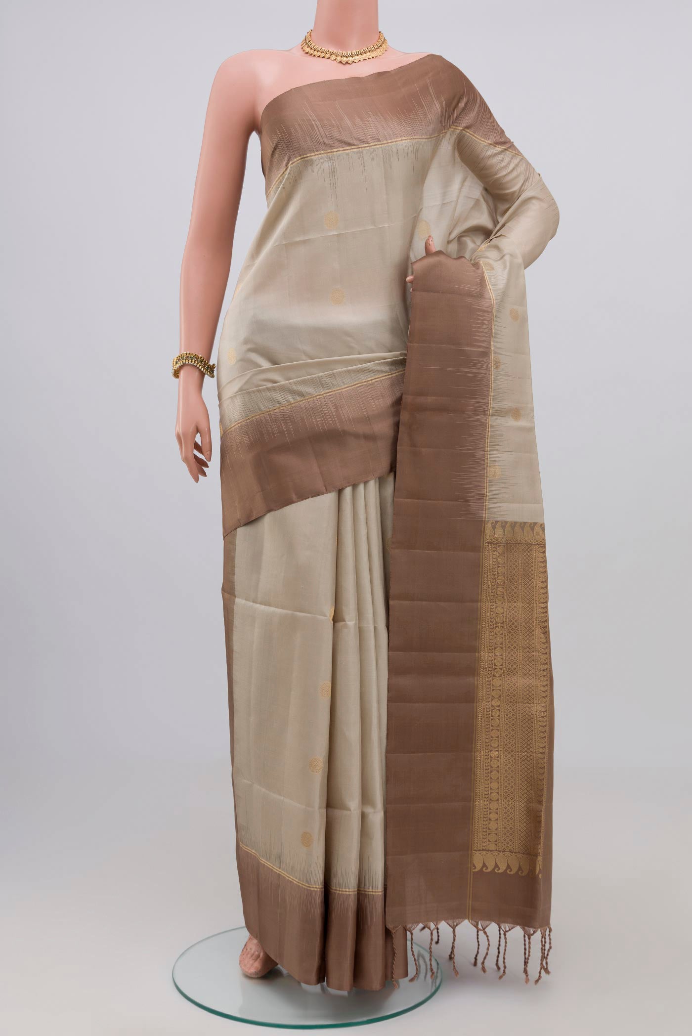Beige Soft Silk Saree with Zari Butta on the body and Plain Border.  displayed on a mannequin