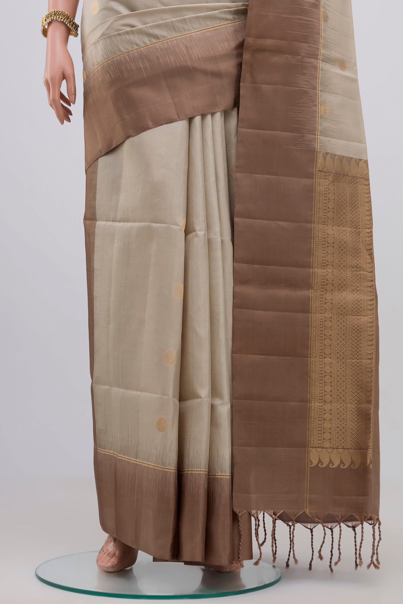Pleats and pallu of Beige Soft Silk Saree with Zari Butta on the body and Plain Border. 