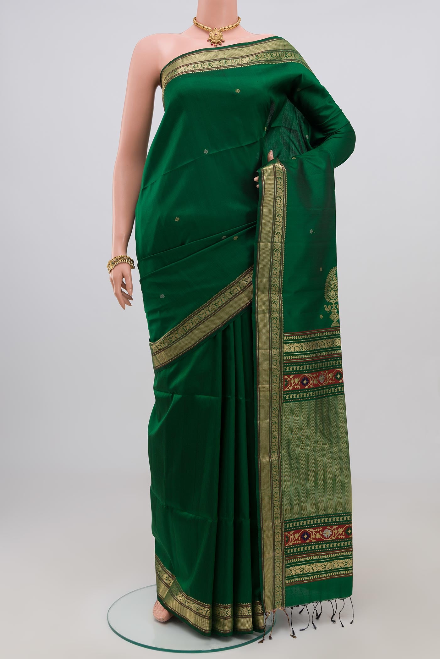 Green Soft Silk Saree with Zari Butta on the body and Zari Border.  displayed on a mannequin