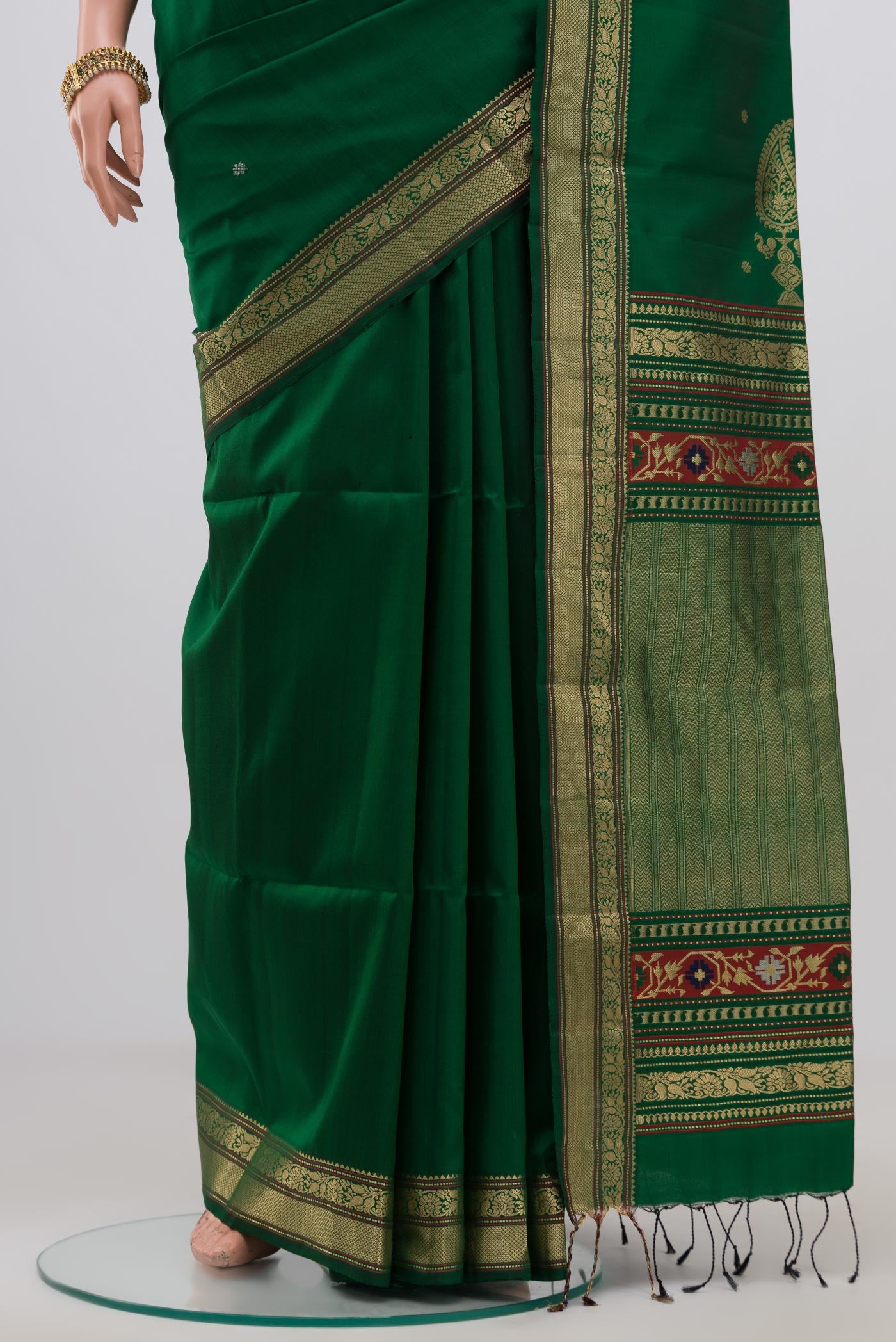 Pleats and pallu of Green Soft Silk Saree with Zari Butta on the body and Zari Border. 