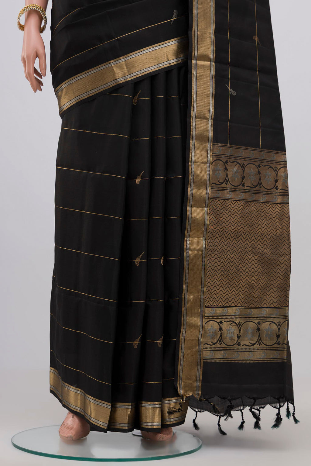Pleats and pallu of Black Soft Silk Saree with Zari Butta on the body and Zari Border. 