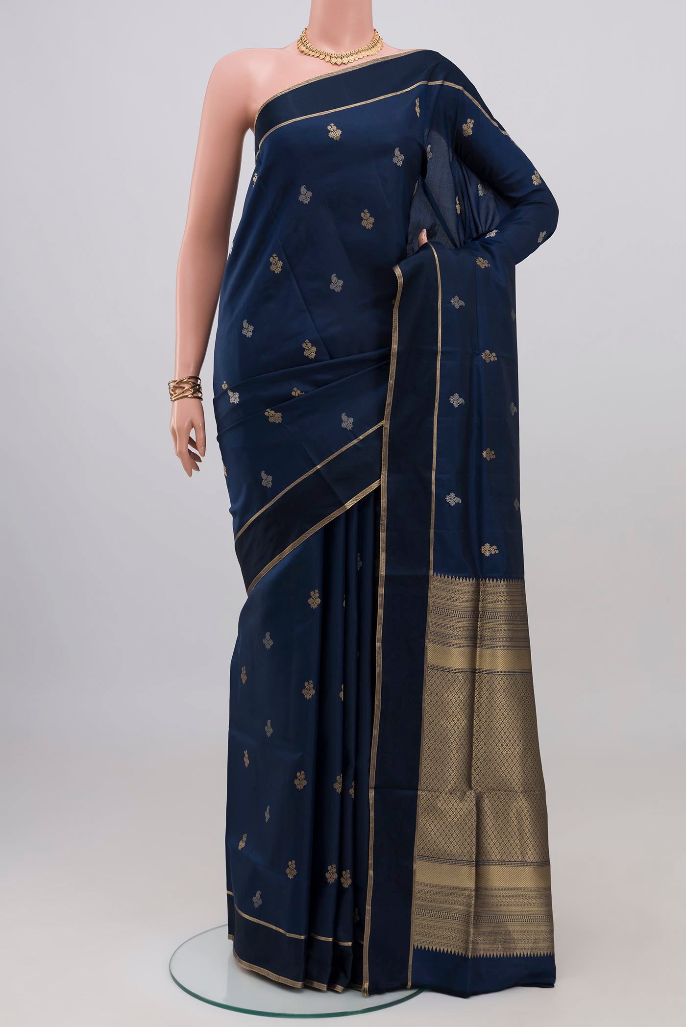 Navy Blue Soft Silk Saree with Zari Butta on the body and Thin Zari Line.  displayed on a mannequin