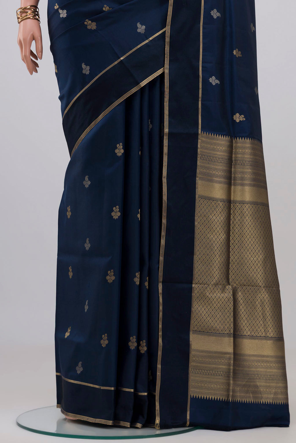 Pleats and pallu of Navy Blue Soft Silk Saree with Zari Butta on the body and Thin Zari Line. 