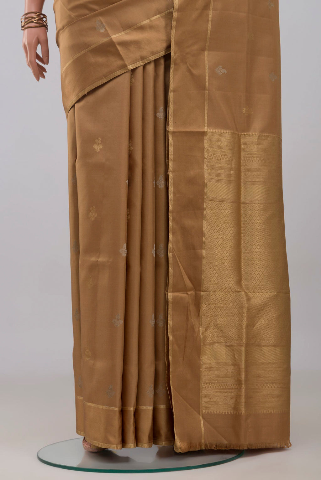 Pleats and pallu of Beige Soft Silk Saree with Zari Butta on the body and Thin Zari Line. 