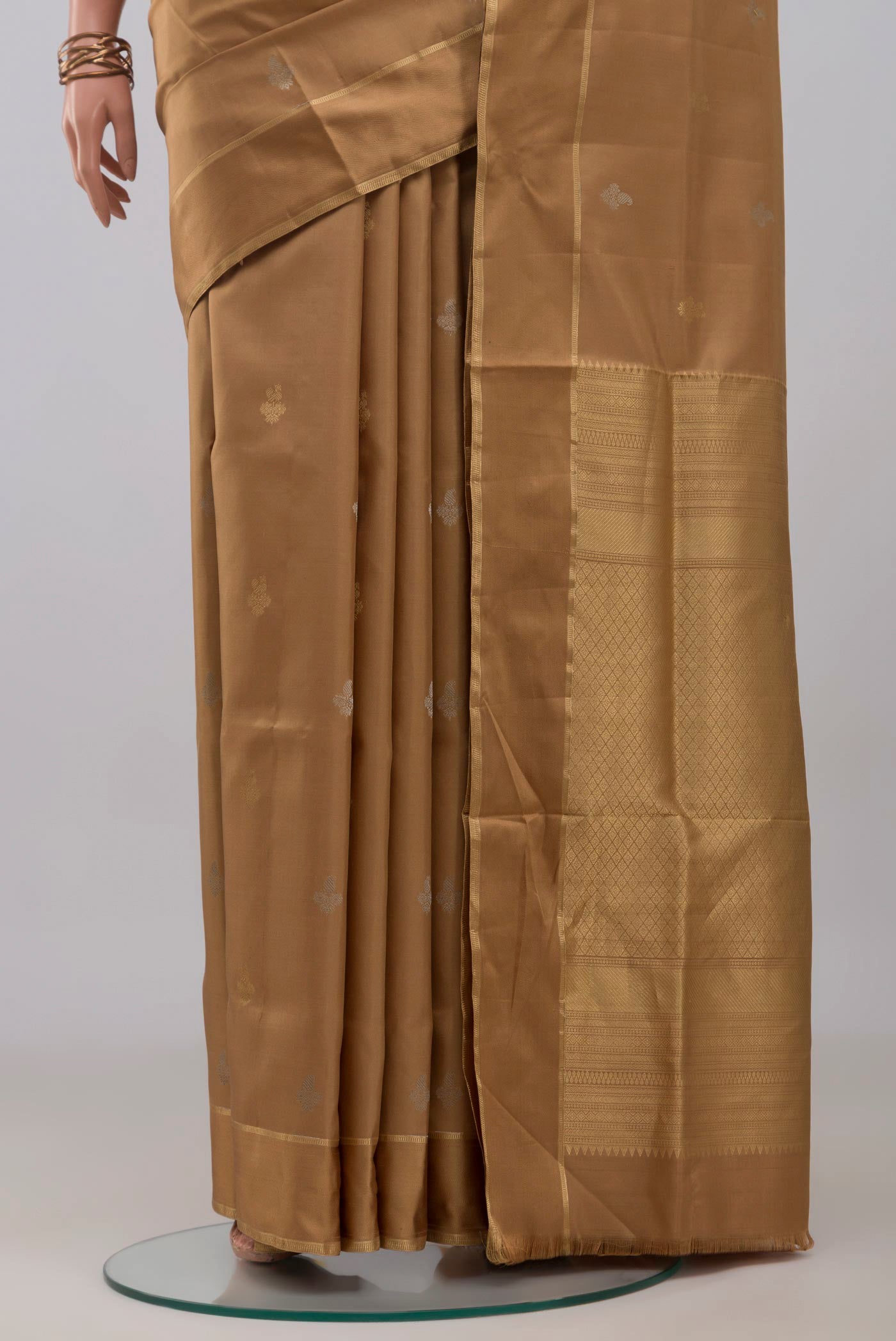 Pleats and pallu of Beige Soft Silk Saree with Zari Butta on the body and Thin Zari Line. 