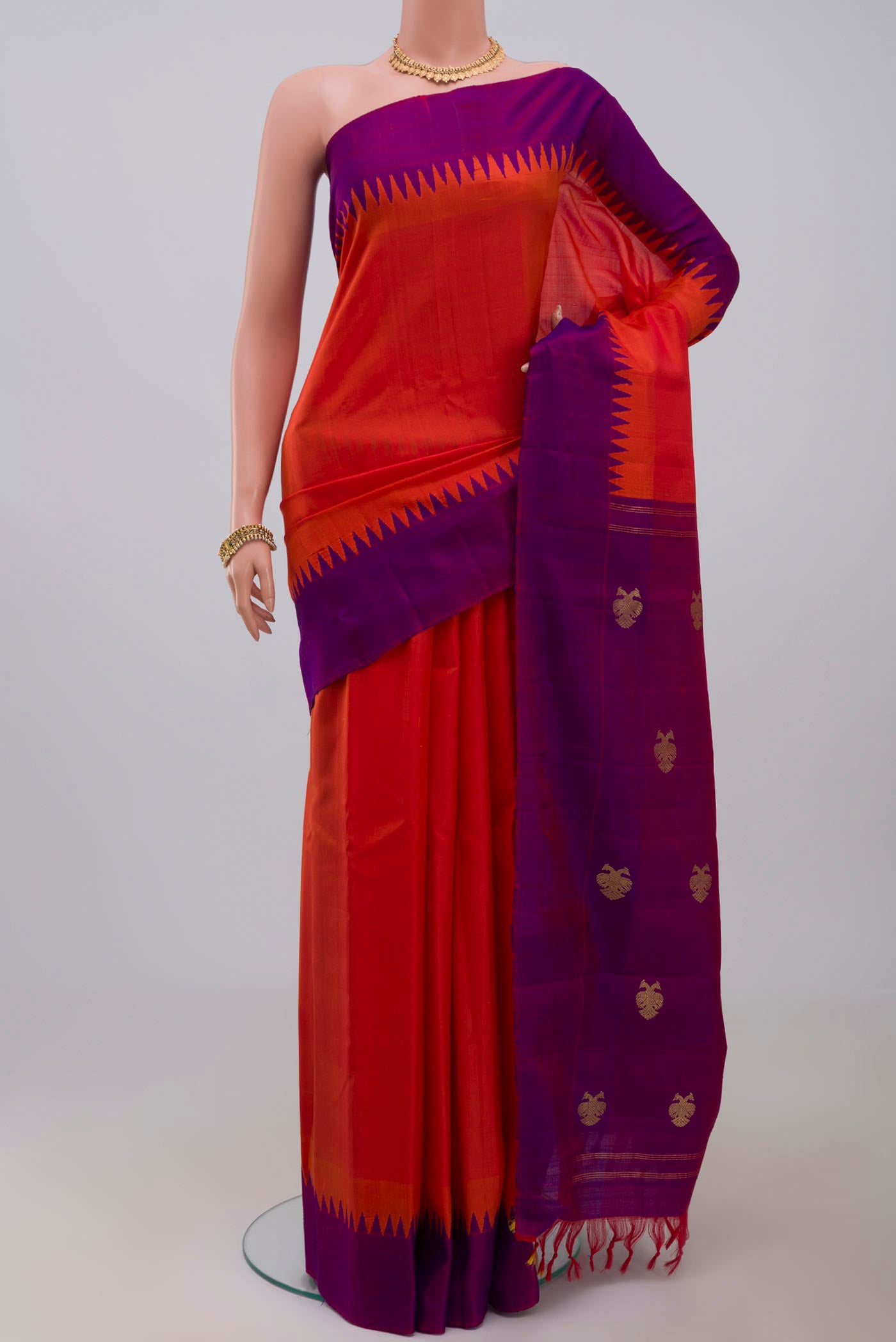 Orange Gadwal Silk Saree with Plain Body and Temple Border.  displayed on a mannequin