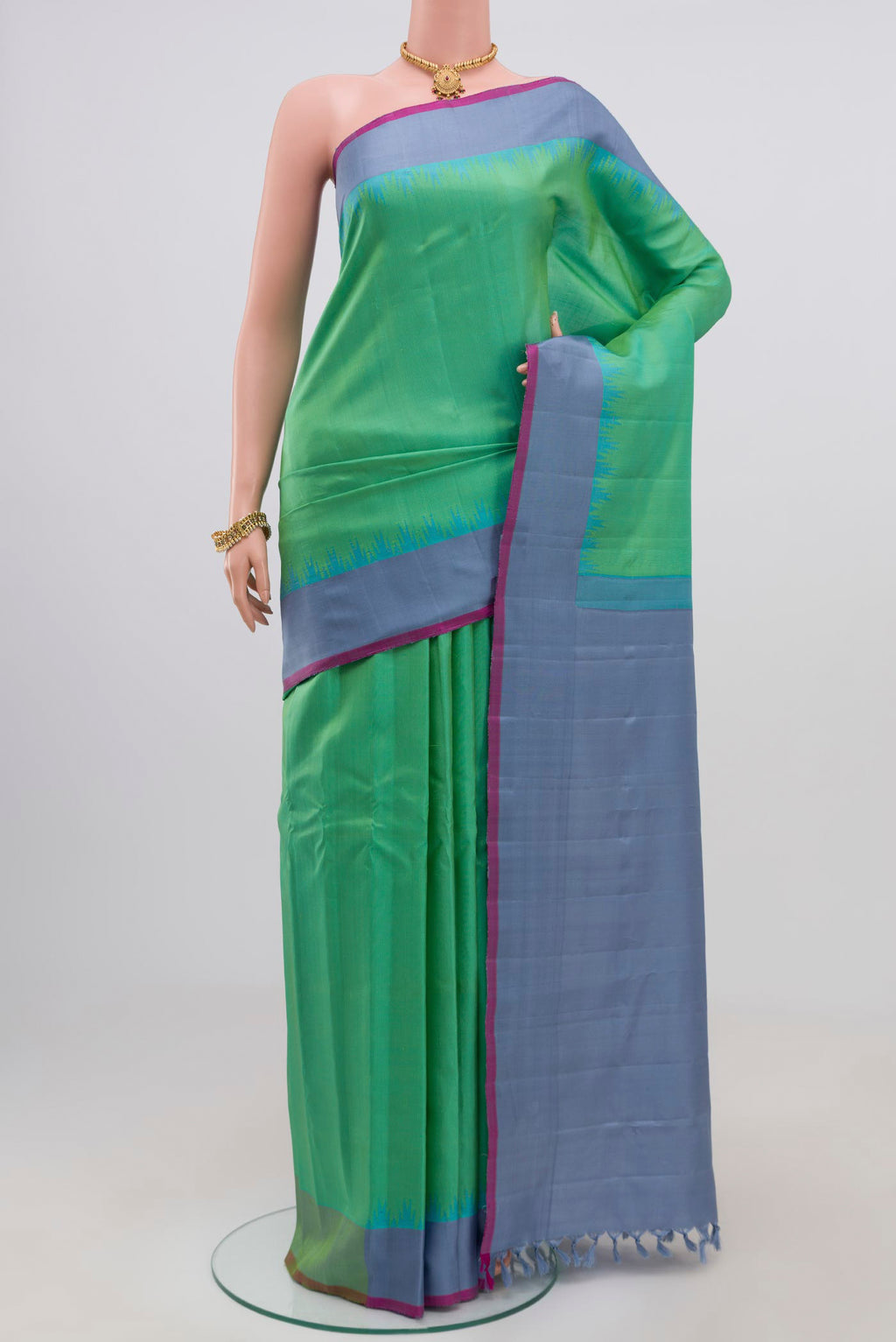 Green Gadwal Silk Saree with Zari Butta on the body and Plain Border.  displayed on a mannequin