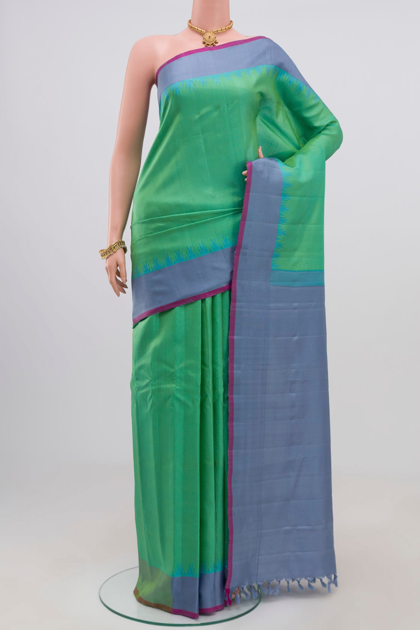 Green Gadwal Silk Saree with Zari Butta on the body and Plain Border.  displayed on a mannequin
