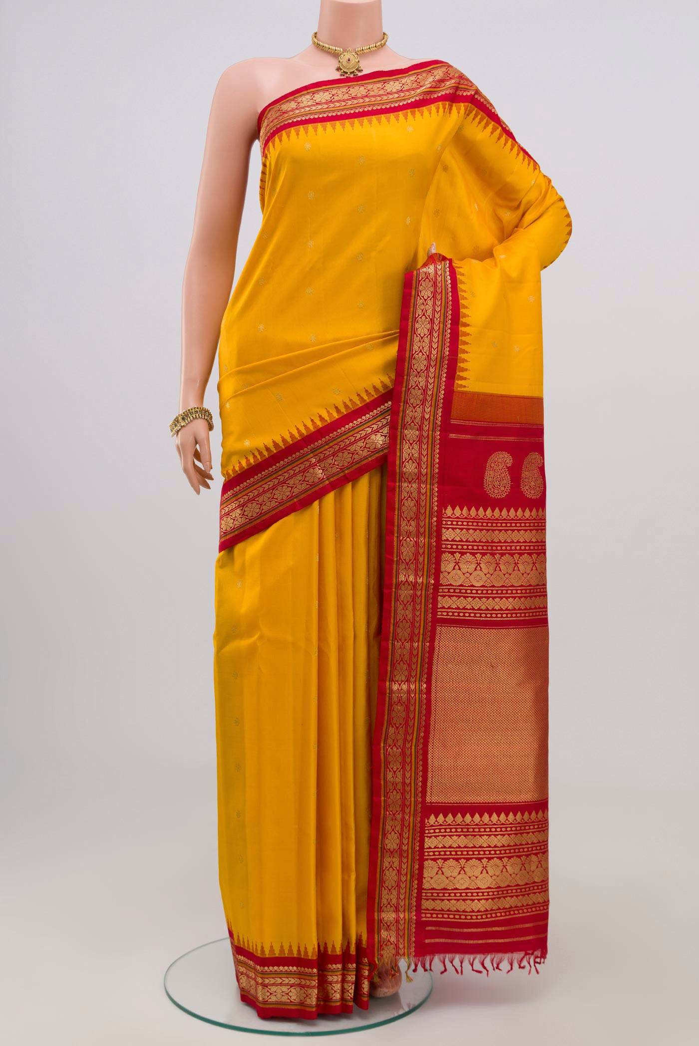 Yellow Gadwal Silk Saree with Zari Butta on the body and Zari Border.  displayed on a mannequin