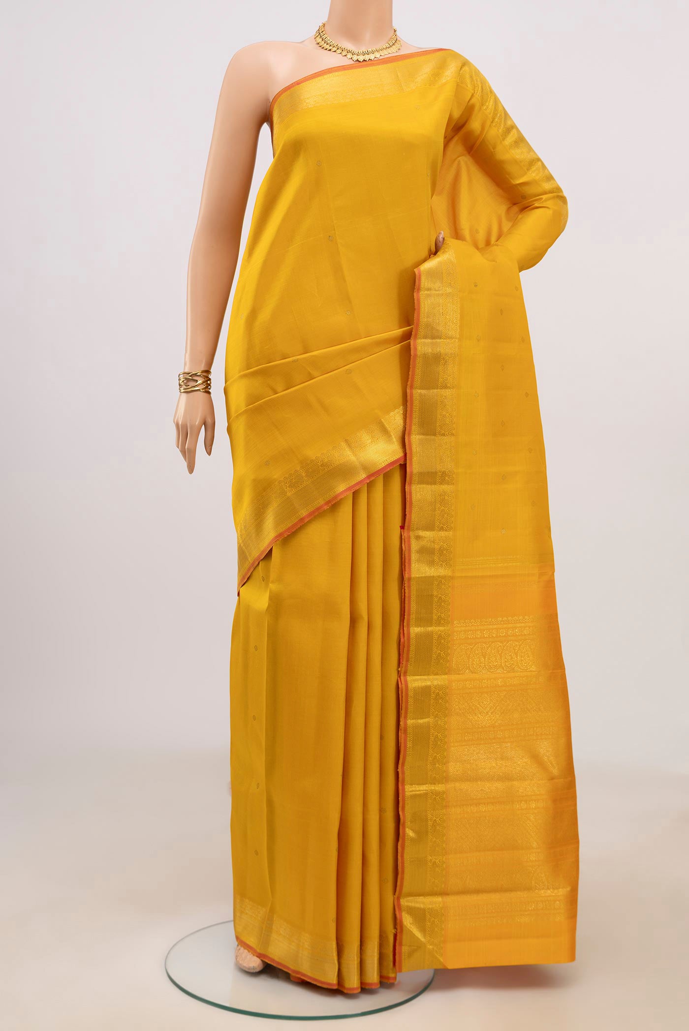 Pure Silk Pure Zari Yellow Kanjivaram Saree with Zari Butta on the body and Zari Border.  displayed on a mannequin