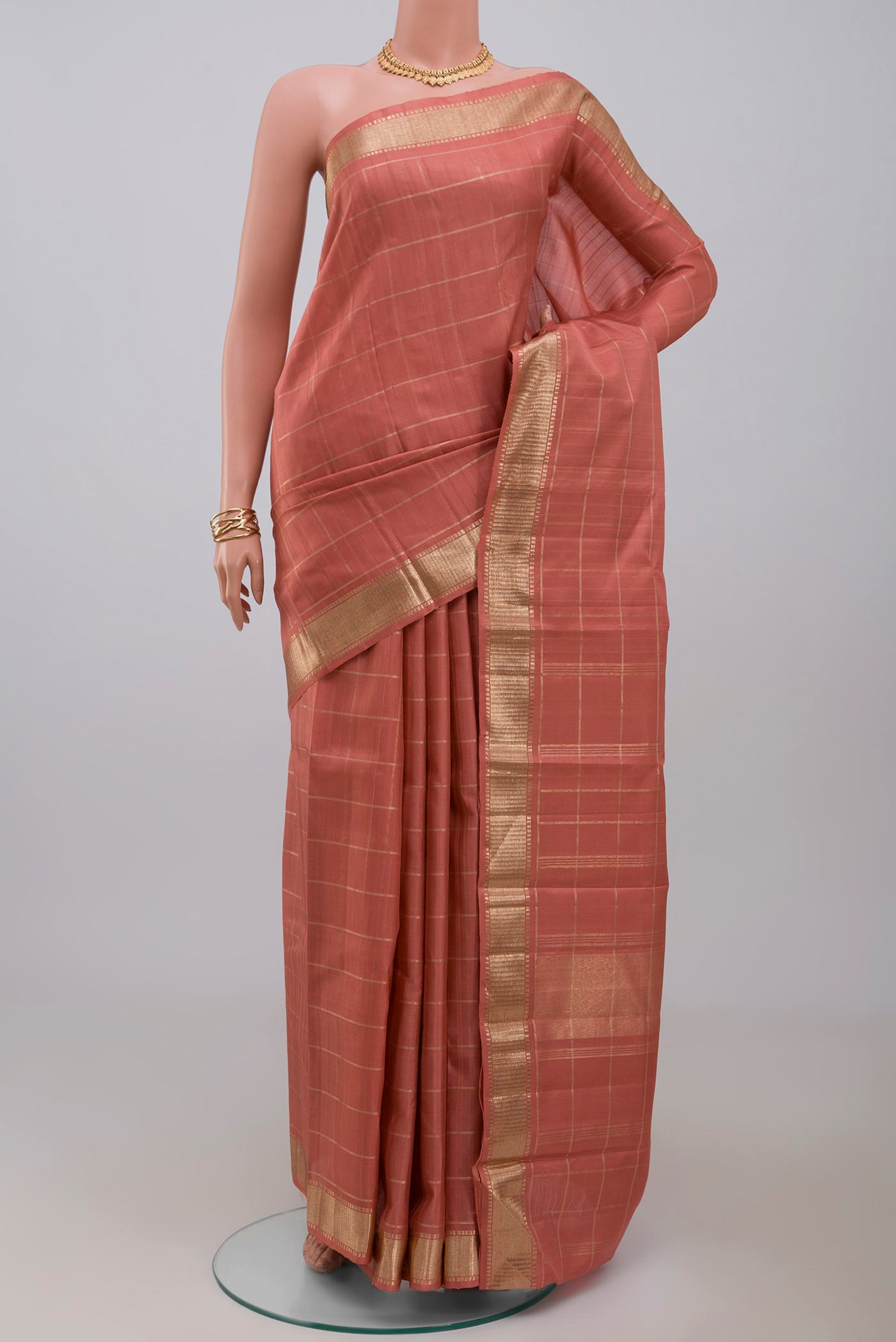 Pure Silk Pure Zari Peach Kanchipuram Saree with Checked design on the body and Zari Border.  displayed on a mannequin