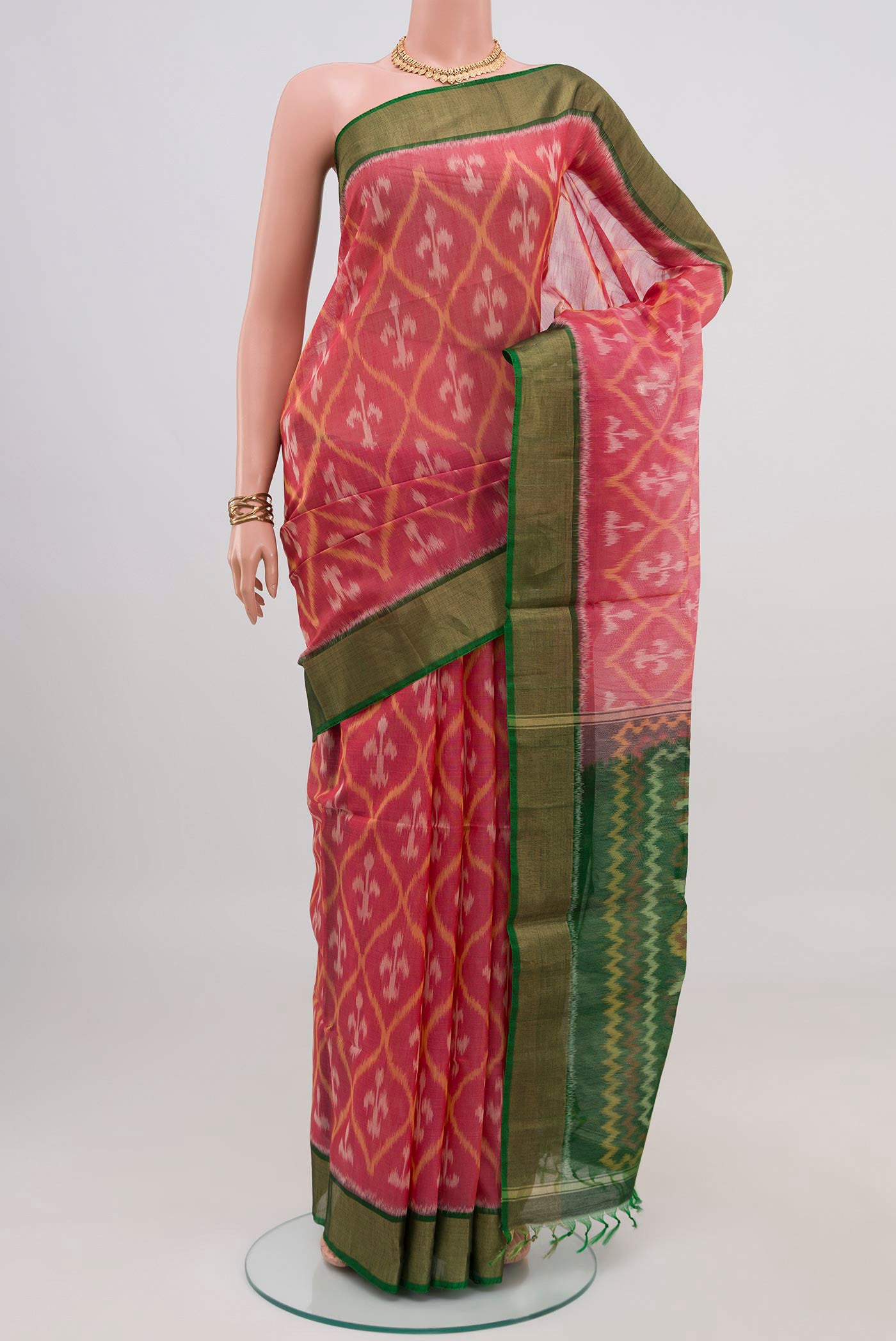 Pink Silk Cotton Saree with Ikat design on the body and Zari Border.  displayed on a mannequin