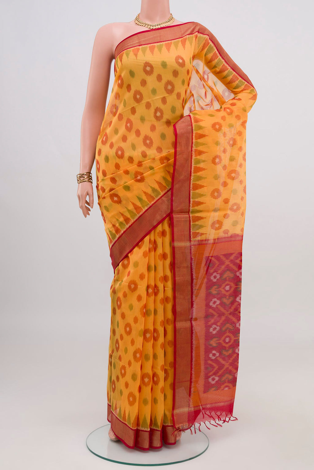 Yellow Silk Cotton Saree with Ikat design on the body and Zari Border.  displayed on a mannequin