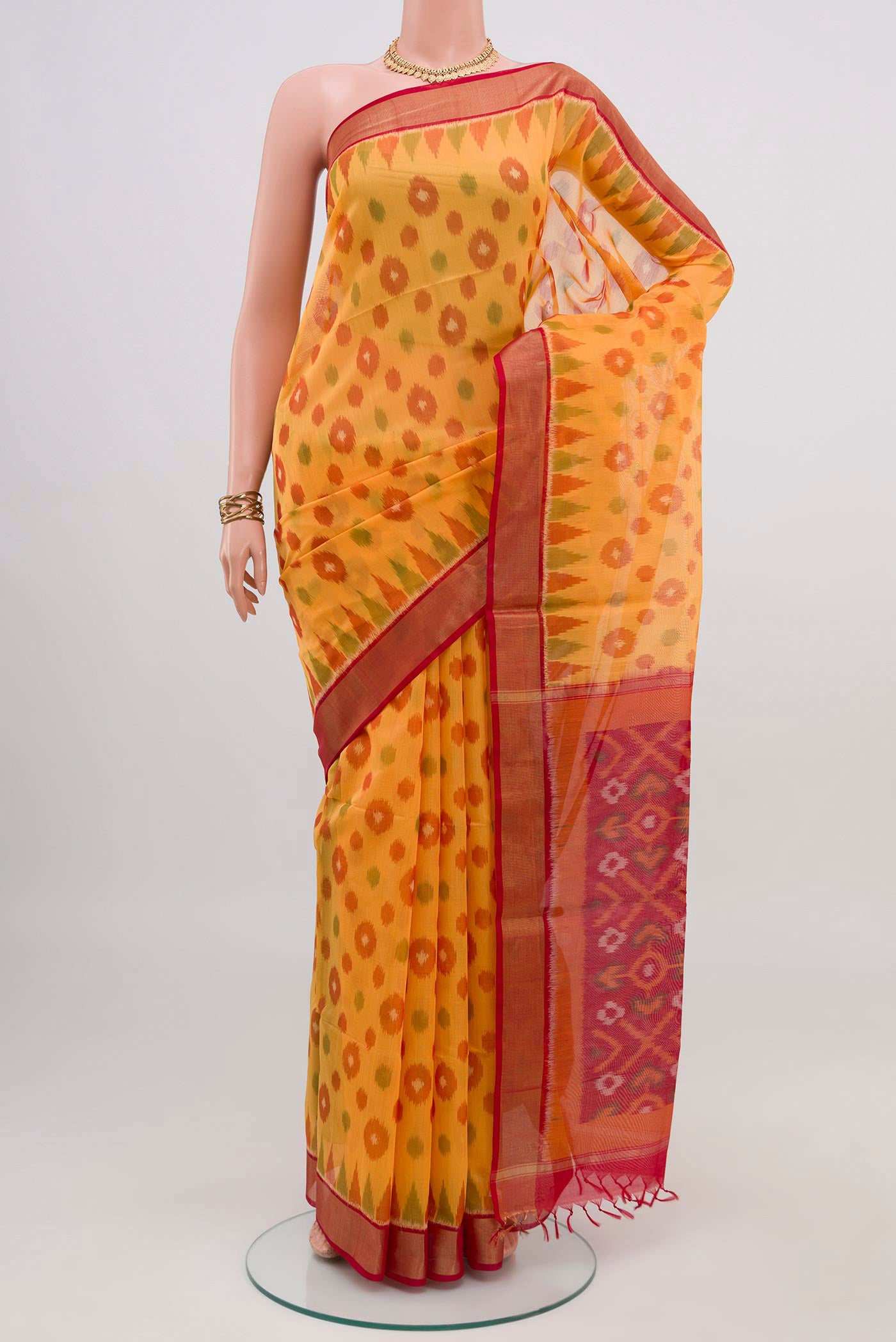 Yellow Silk Cotton Saree with Ikat design on the body and Zari Border.  displayed on a mannequin