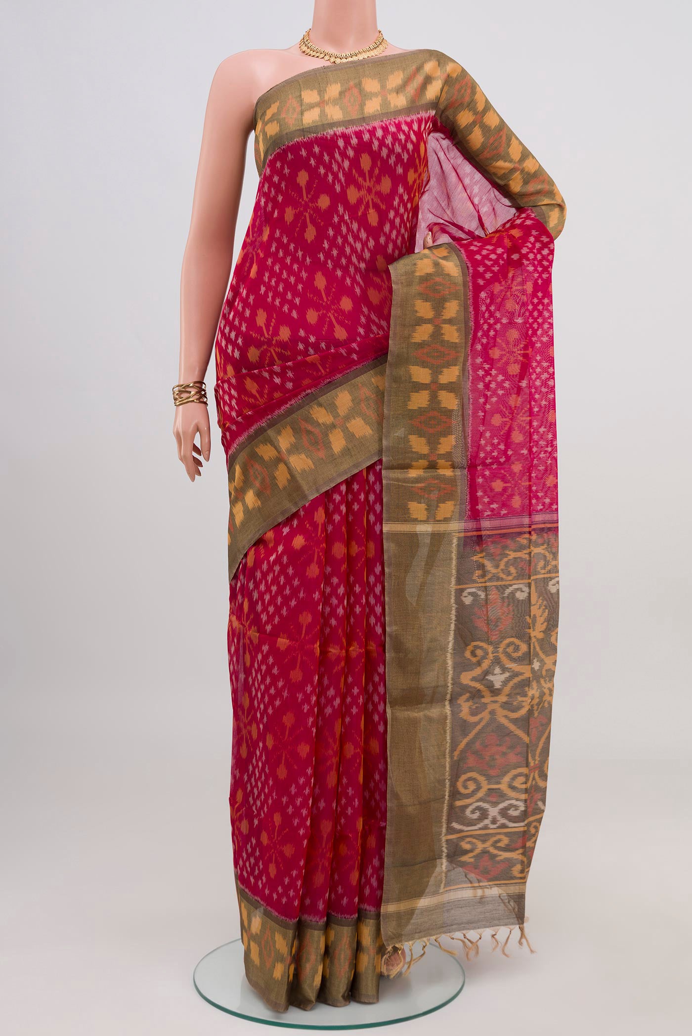 Pink Silk Cotton Saree with Ikat design on the body and Zari Border.  displayed on a mannequin