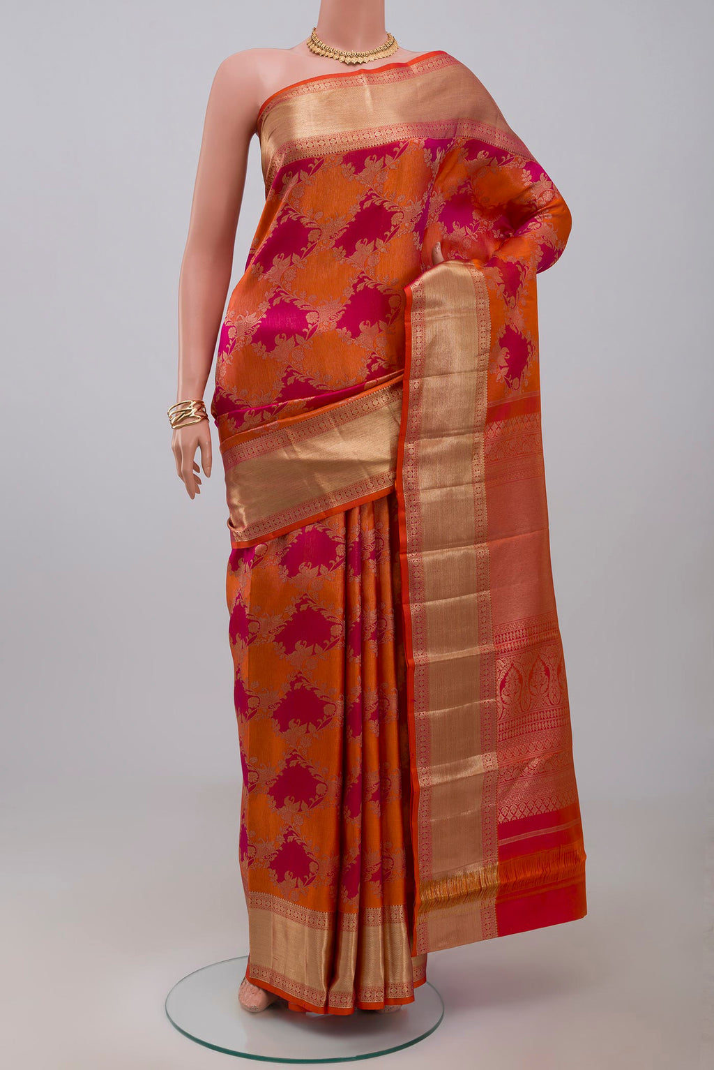 Orange Kanjivaram Saree with Zari Brocade on the body and Zari Border.  displayed on a mannequin