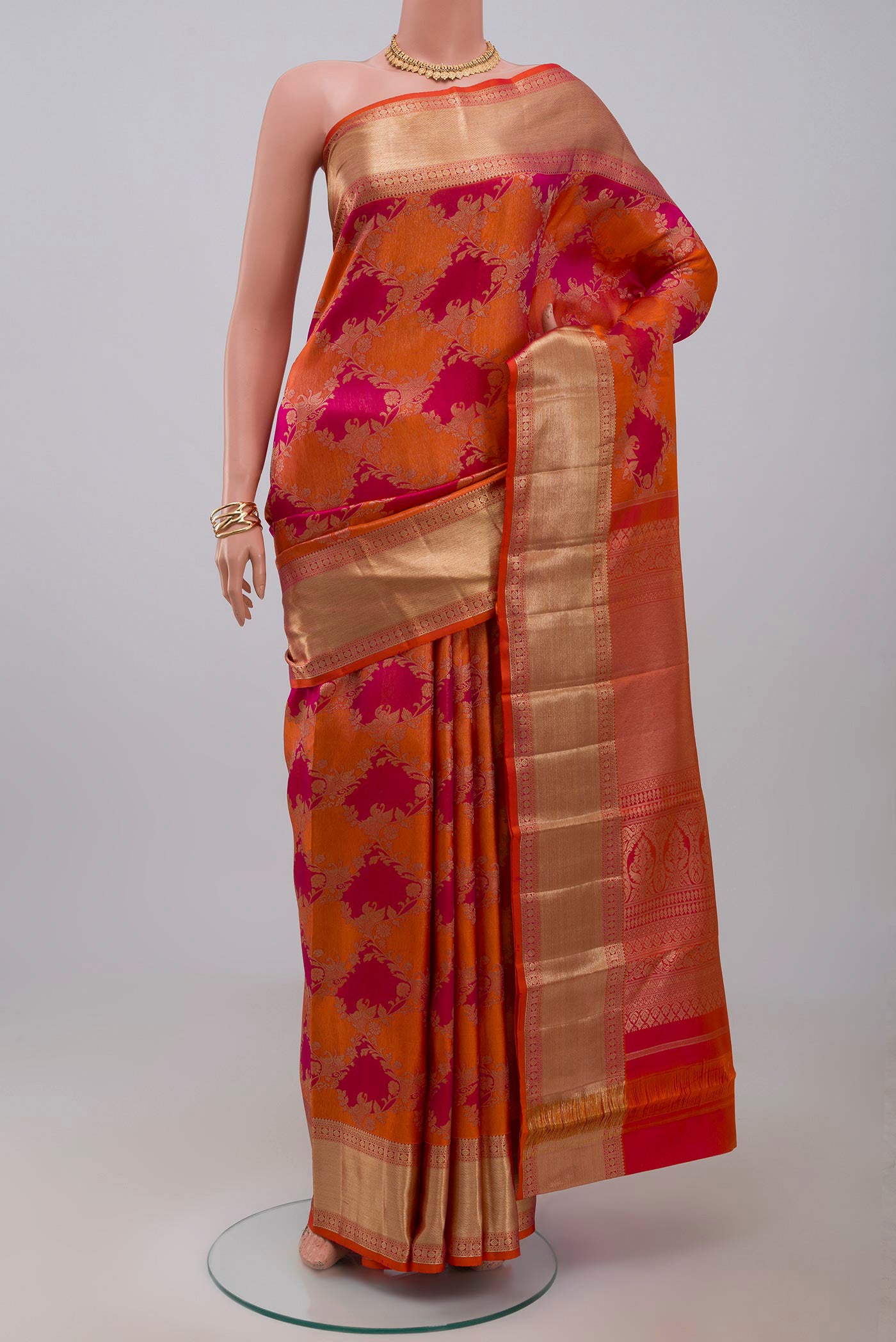 Orange Kanjivaram Saree with Zari Brocade on the body and Zari Border.  displayed on a mannequin