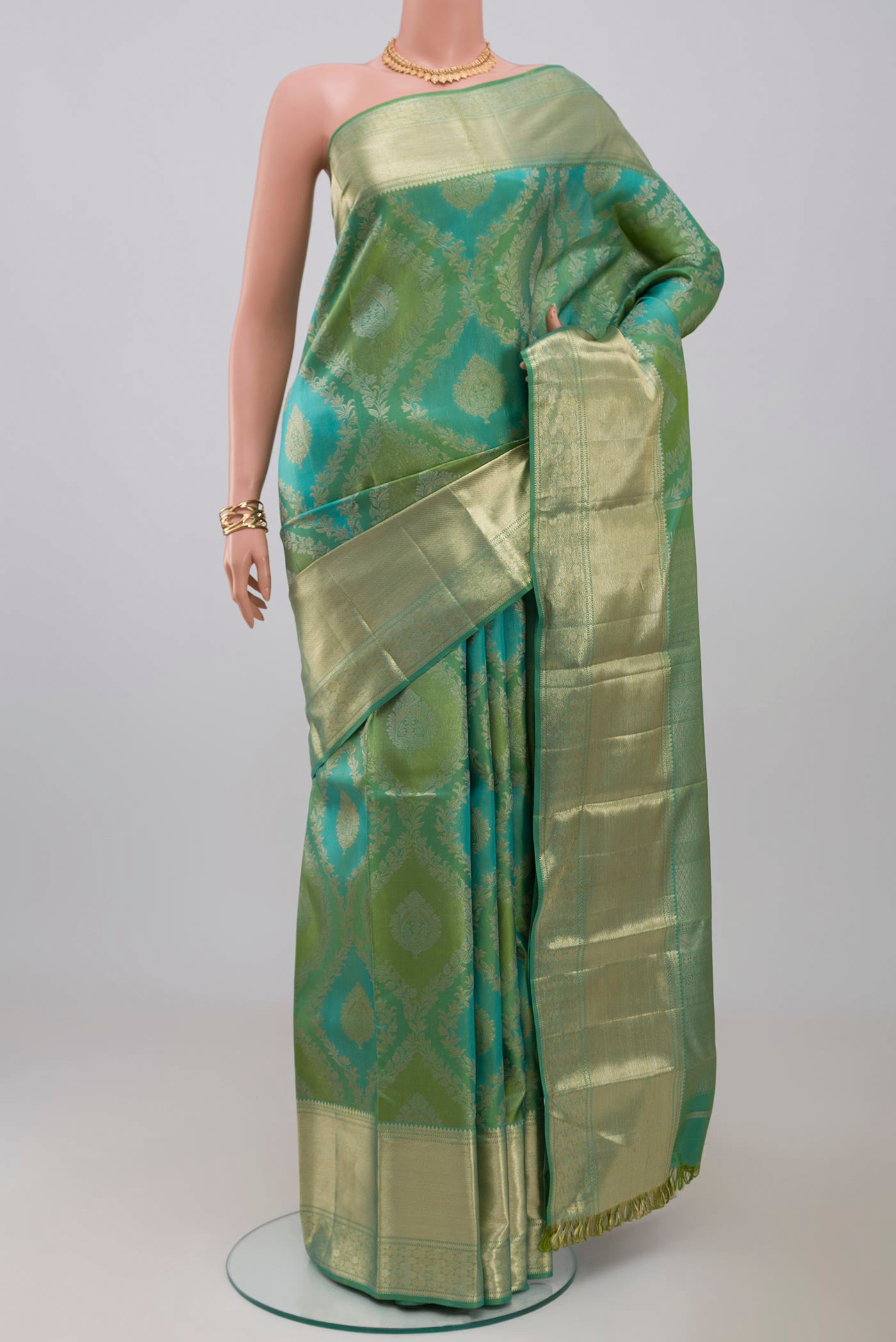 Green Kanjivaram Silk Saree with Zari Brocade on the body and Zari Border.  displayed on a mannequin