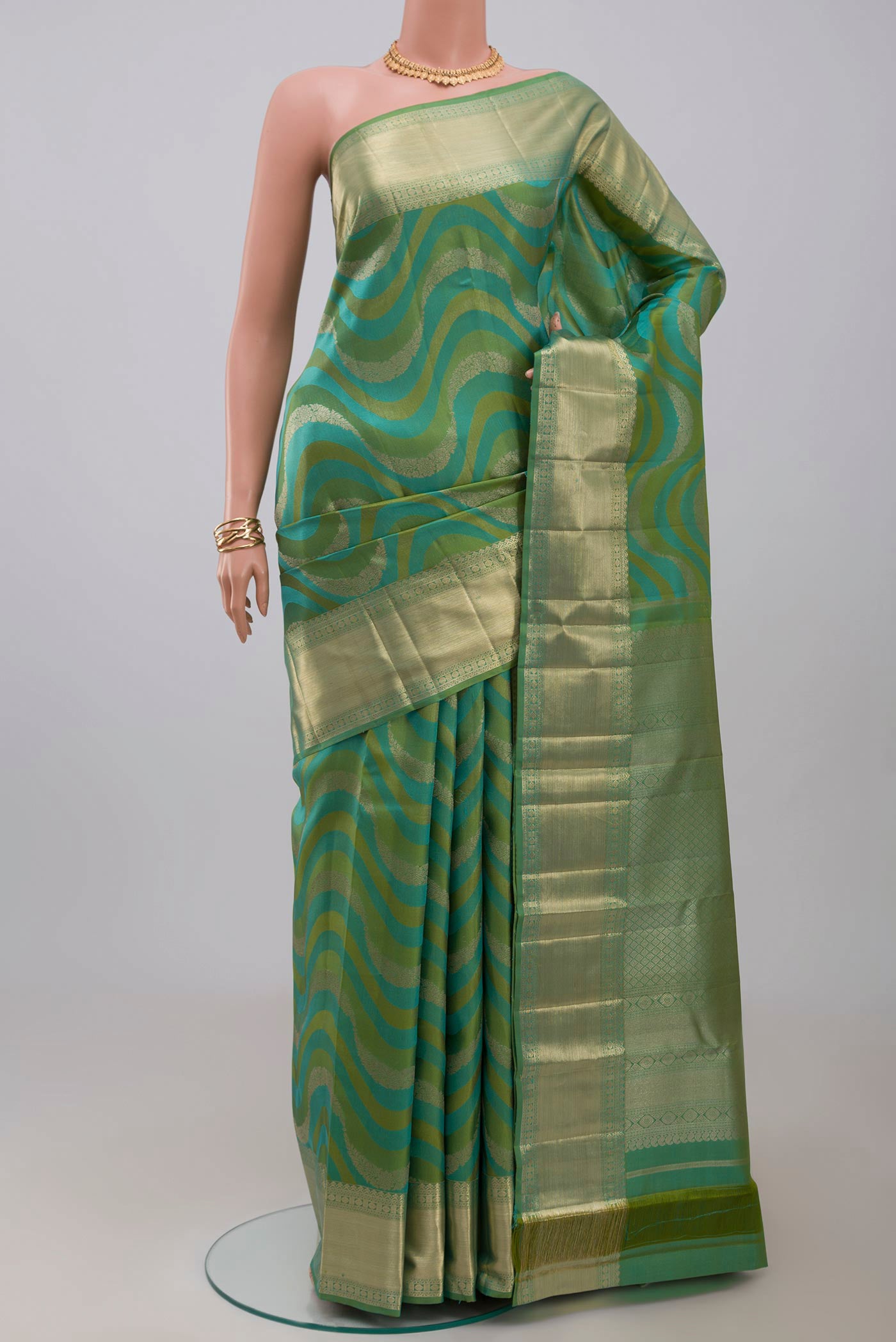 Green Kanjivaram Silk Saree with Zari Brocade on the body and Zari Border.  displayed on a mannequin