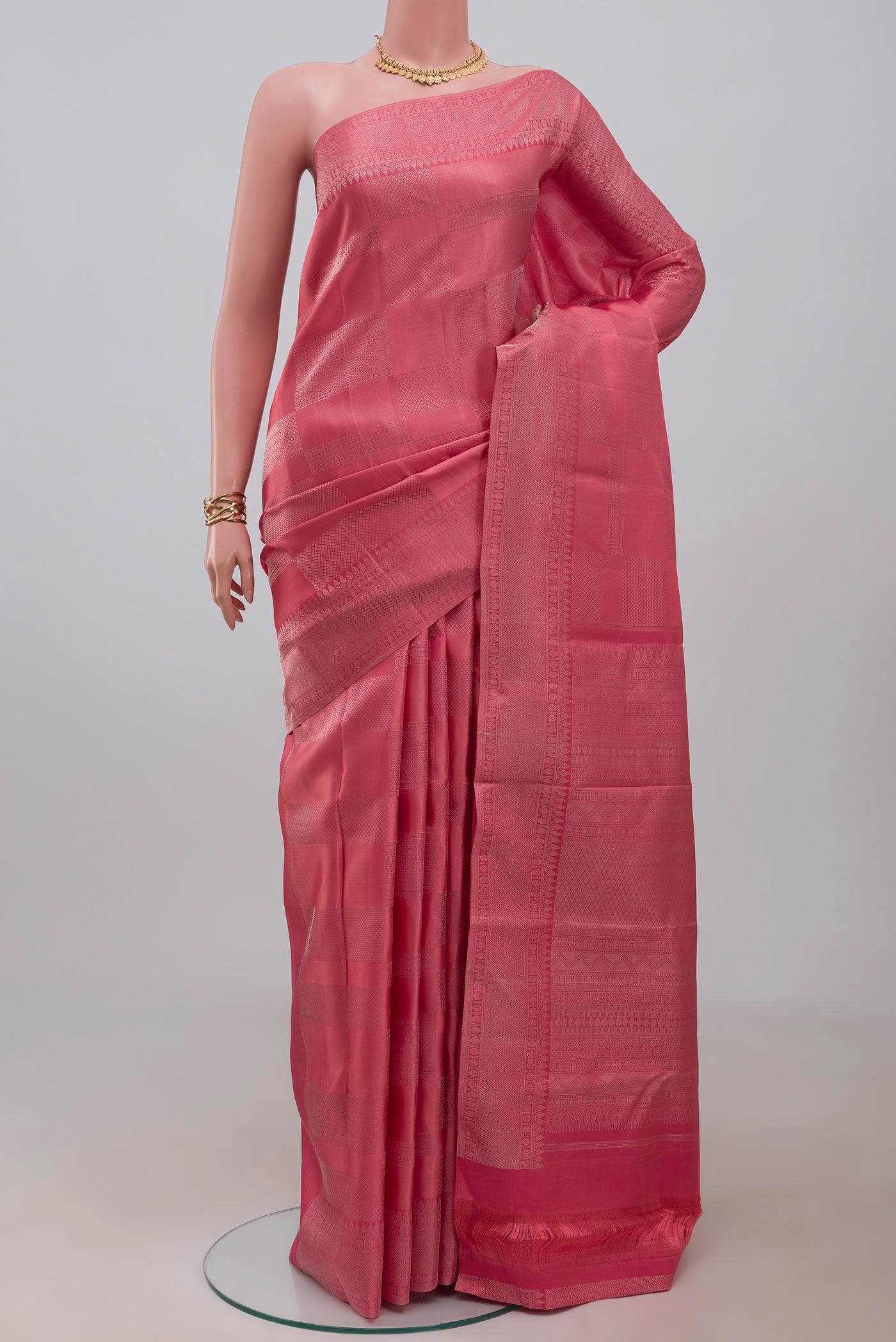 Peach Kanjivaram Silk Saree with Zari Brocade on the body and Zari Border.  displayed on a mannequin