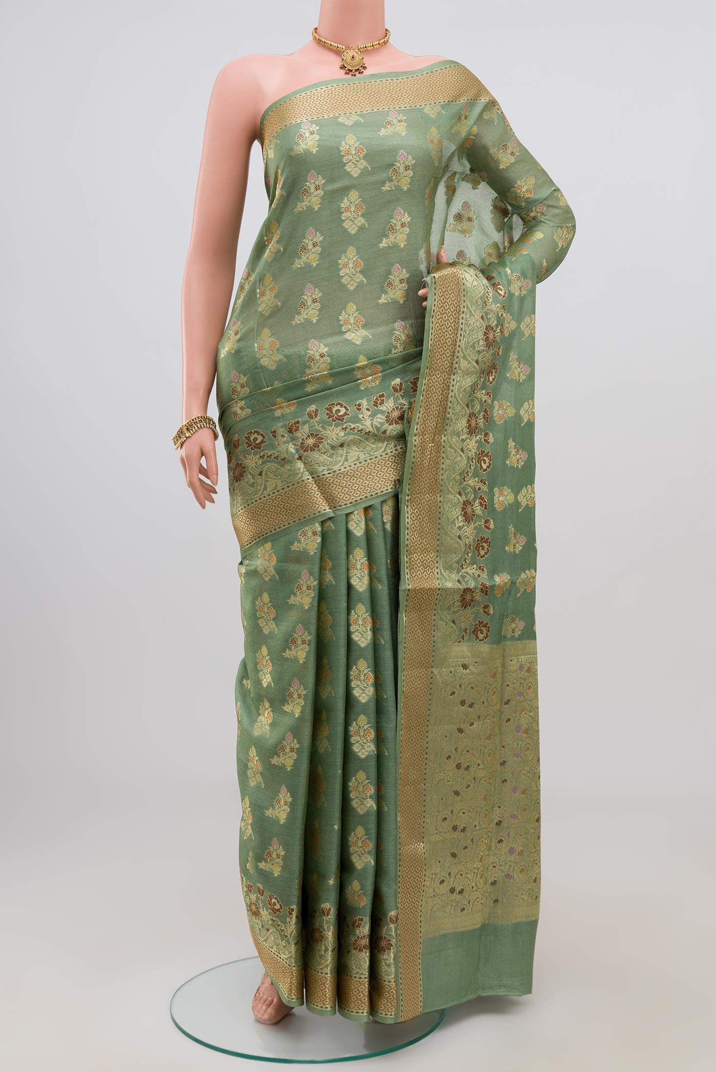 Pista Green Tussar Silk Saree with Zari Butta on the body and Zari Border.  displayed on a mannequin