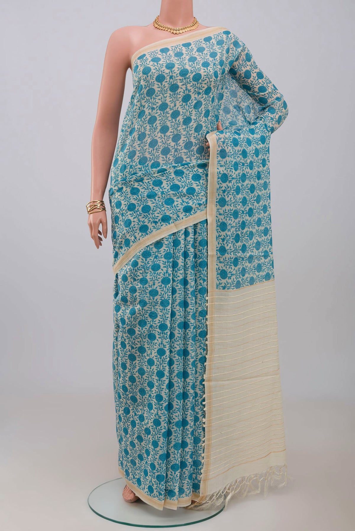 Cream Tussar Saree with Printed design on the body and Thin Zari Line.  displayed on a mannequin