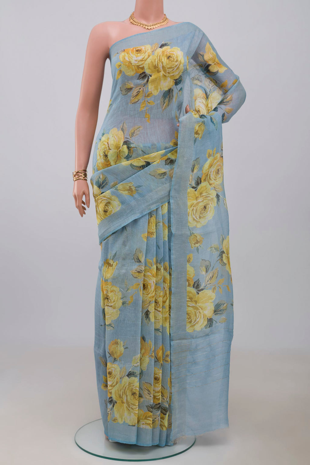 Sky Blue Linen Cotton Saree with Floral Print on the body and Thin Zari Line.  displayed on a mannequin