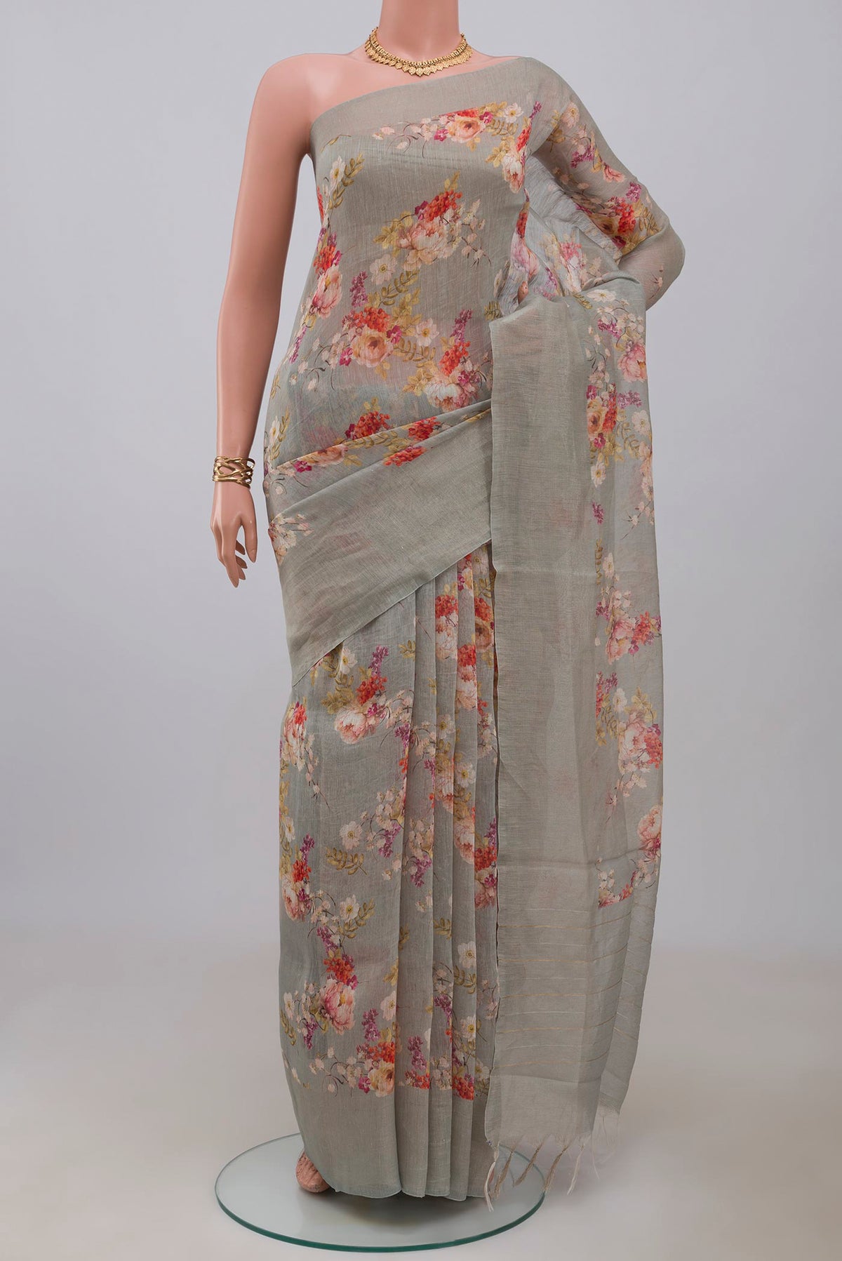 Grey Linen Saree with Floral Print on the body and Thin Zari Line.  displayed on a mannequin