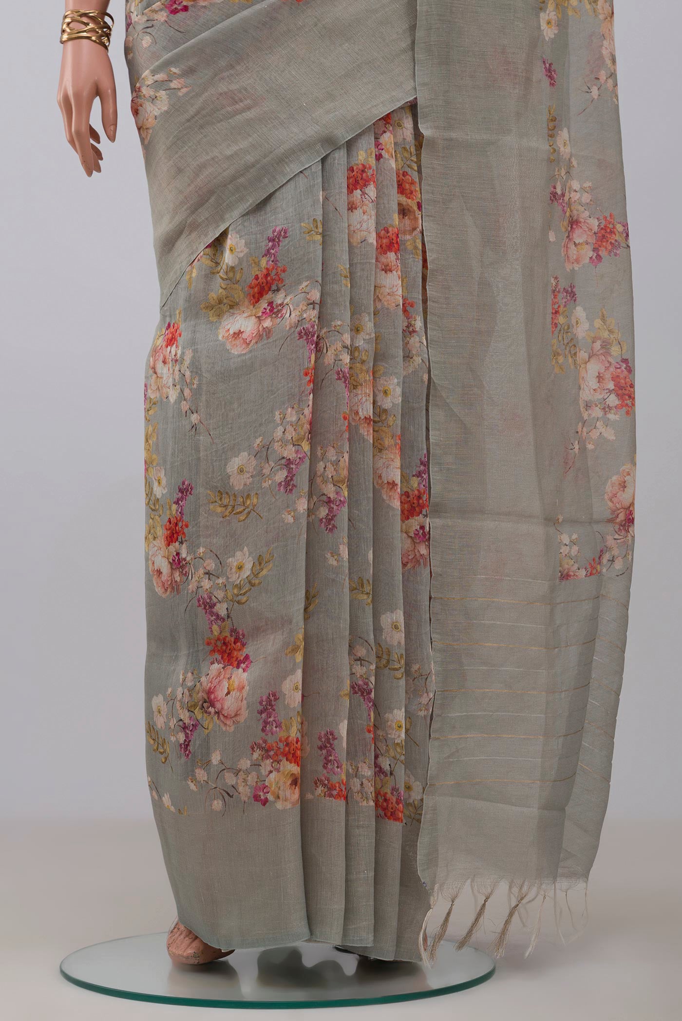 Pleats and pallu of Grey Linen Saree with Floral Print on the body and Thin Zari Line. 