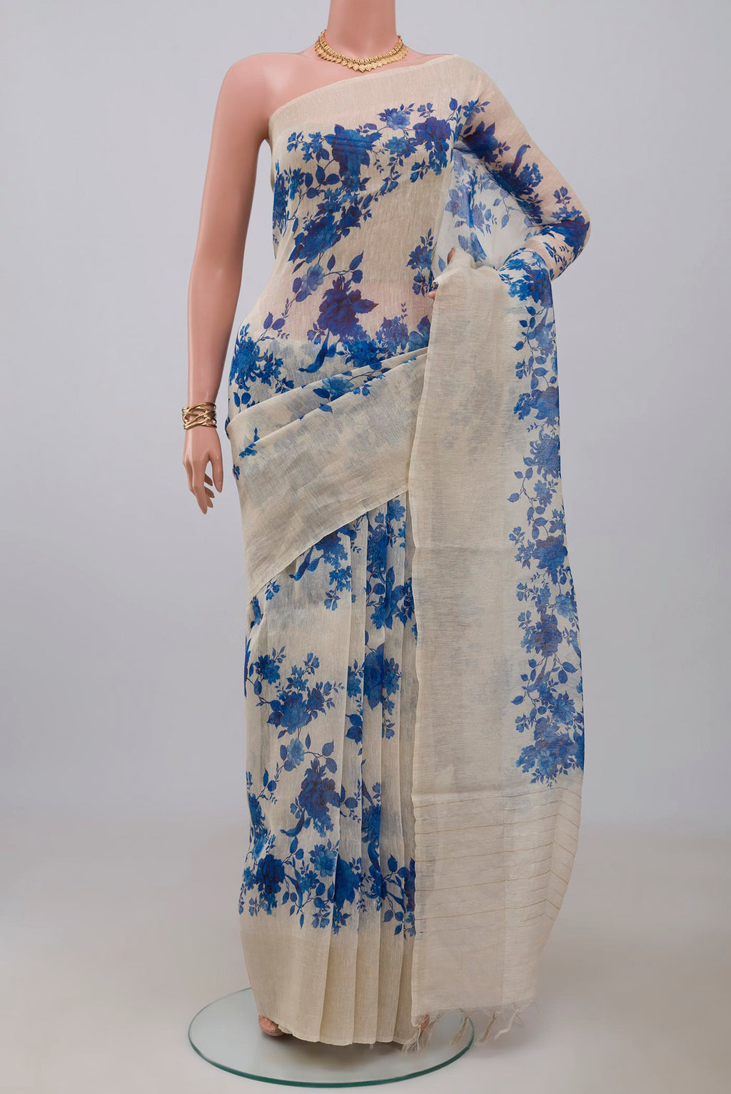 Cream Linen Saree with Floral Print on the body and Thin Zari Line.  displayed on a mannequin