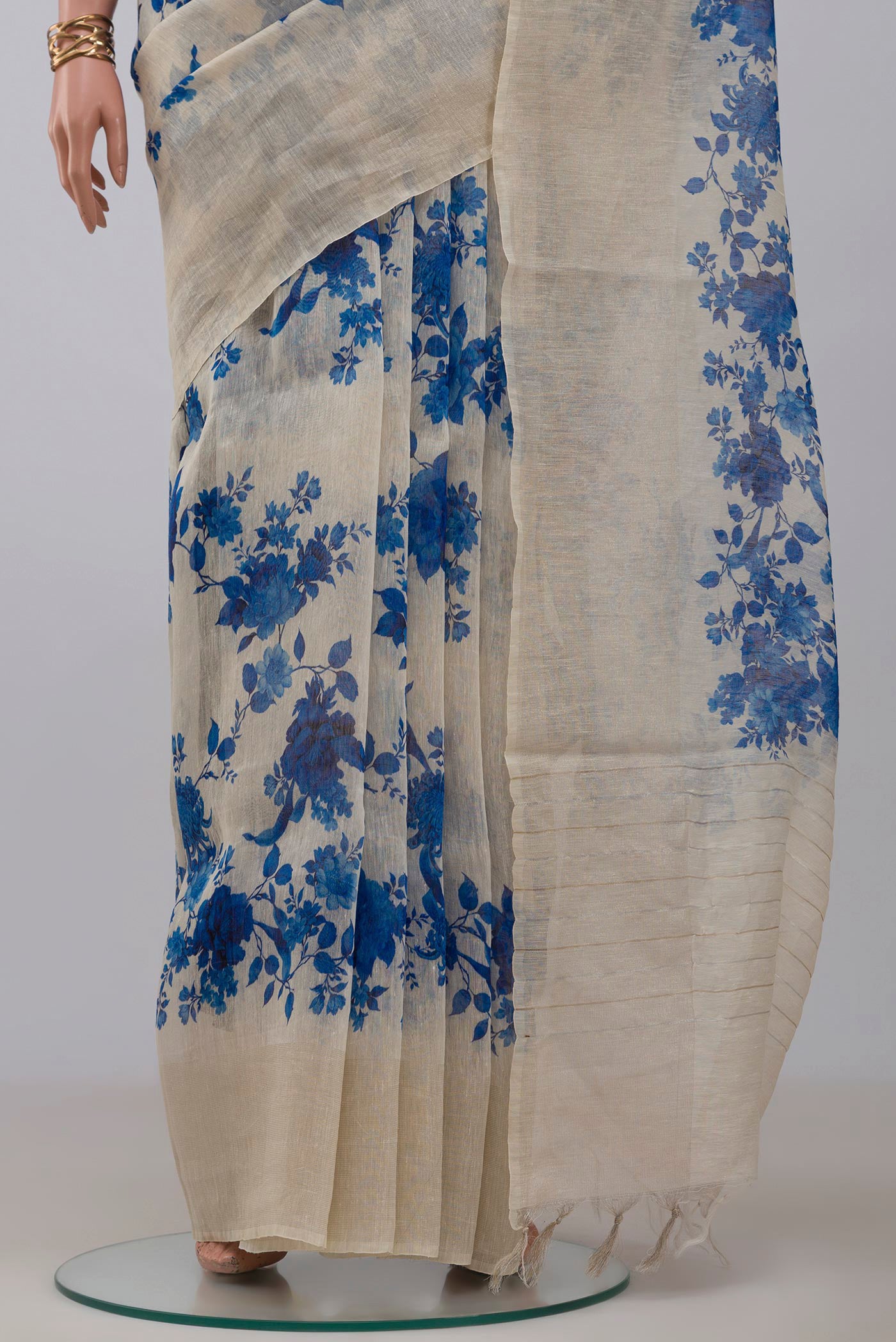 Pleats and pallu of Cream Linen Saree with Floral Print on the body and Thin Zari Line. 