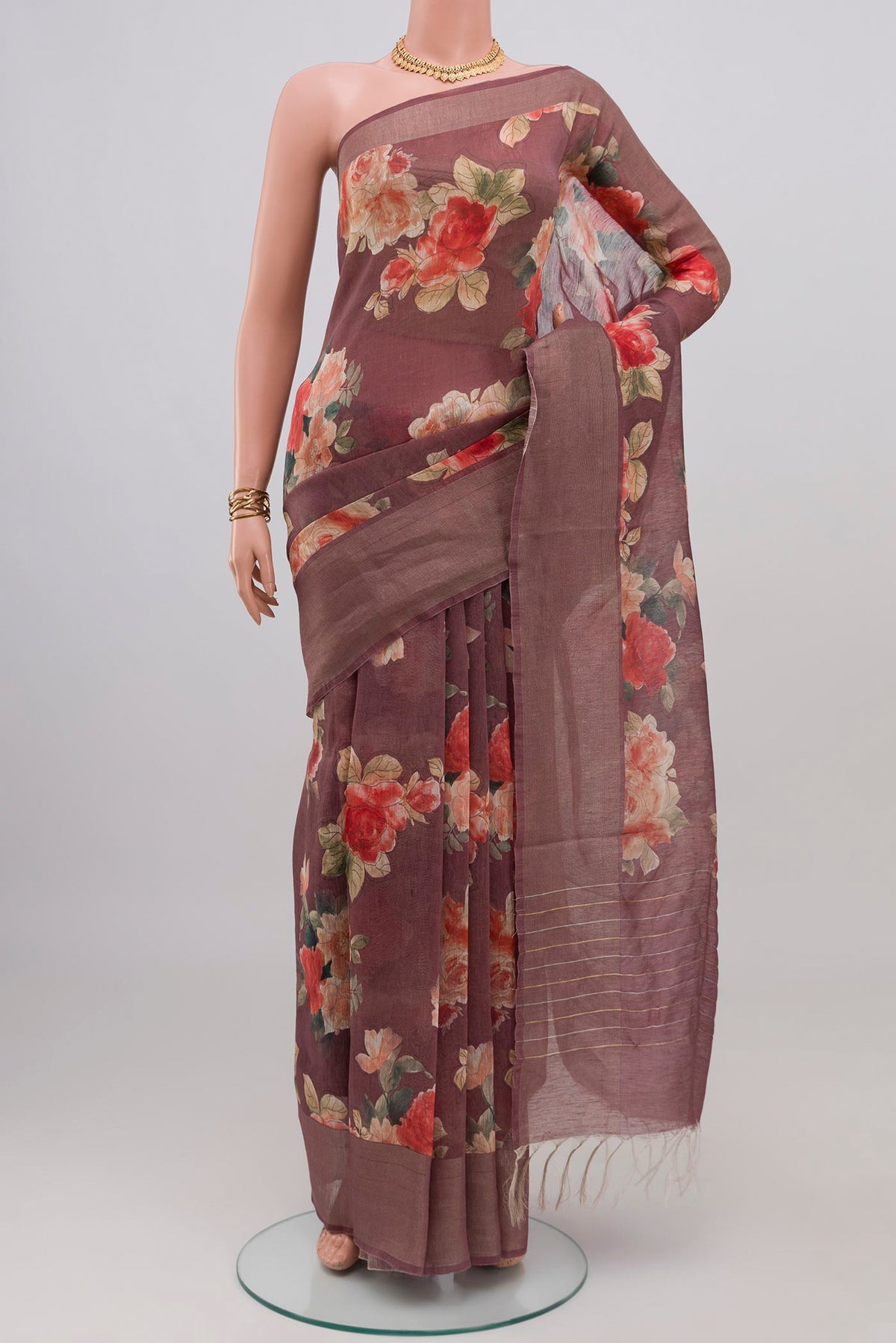 Mauve Linen Saree with Floral Print on the body and Thin Zari Line.  displayed on a mannequin
