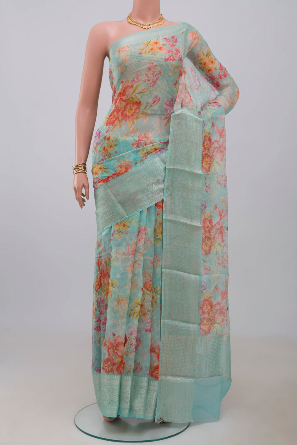 Light Blue Kota Silk Saree with Floral Print on the body and Zari Border.  displayed on a mannequin