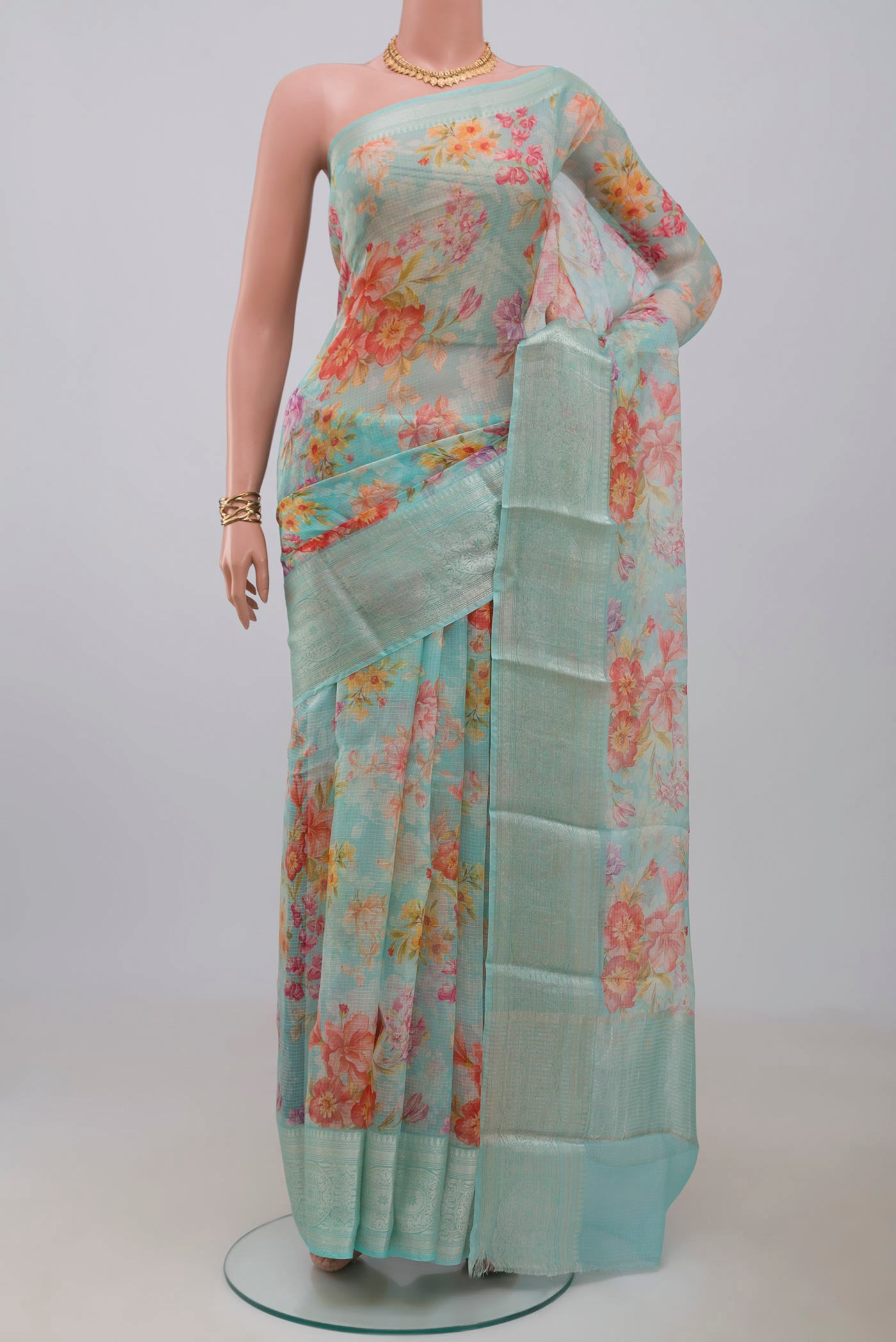 Light Blue Kota Silk Saree with Floral Print on the body and Zari Border.  displayed on a mannequin