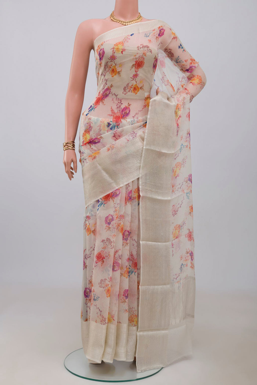 Cream Kota Silk Saree with Floral Print on the body and Zari Border.  displayed on a mannequin