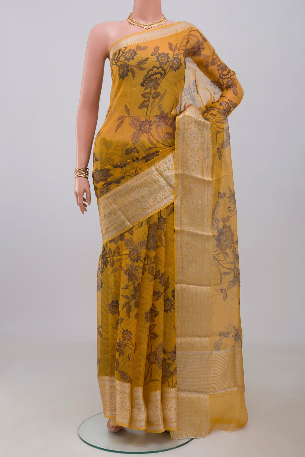 Mustard Kota Silk Saree with Printed design on the body and Zari Border.  displayed on a mannequin