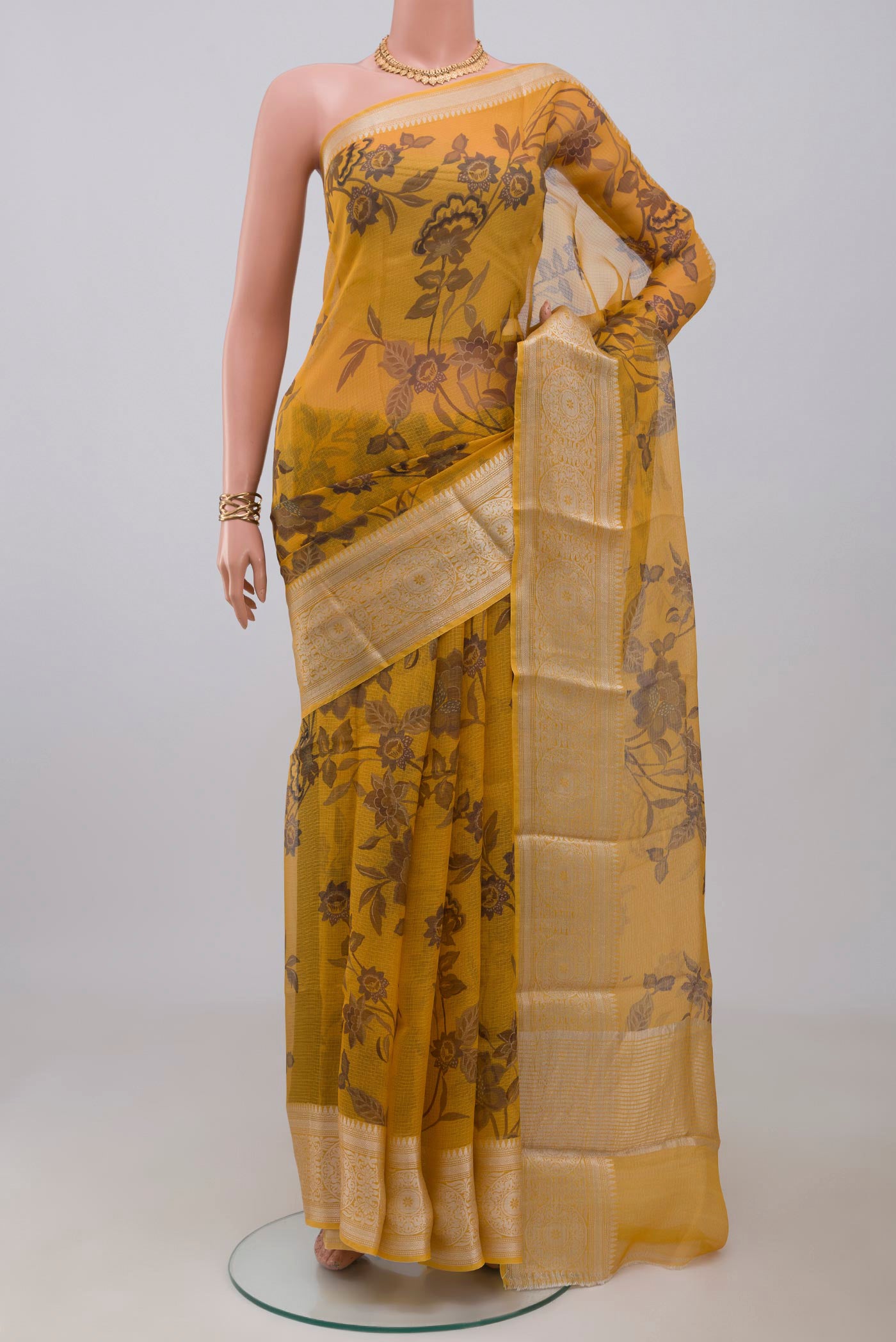 Mustard Kota Silk Saree with Printed design on the body and Zari Border.  displayed on a mannequin